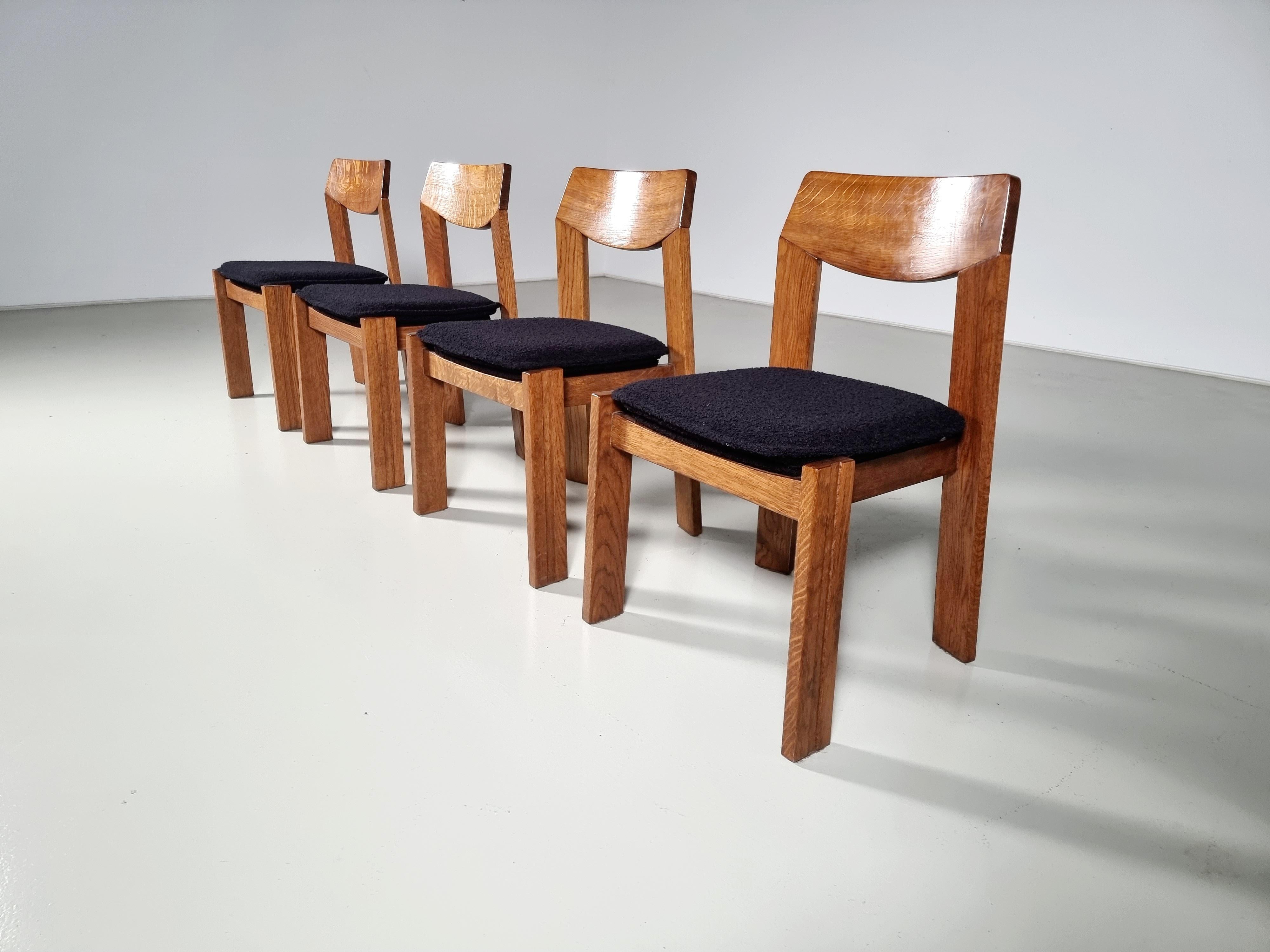Set of 4 brutalist solid oak dining chairs from the 1970s. Bulky chairs with amazing seating comfort because of the curved backrest and soft seat. Reupholstered in a black boucle by Bisson Bruneel France.