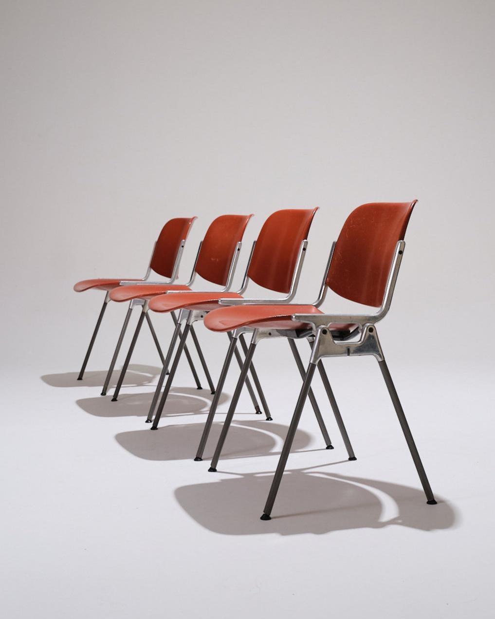 Set di 4 sedie da pranzo o da ufficio, modello DSC 106 di Giancarlo Piretti, prodotto da Castelli negli anni '70.
Struttura in metallo cromato con seduta e schienale in polimero arancione. Numerato e firmato sulla cornice. Segni di usura visibili,