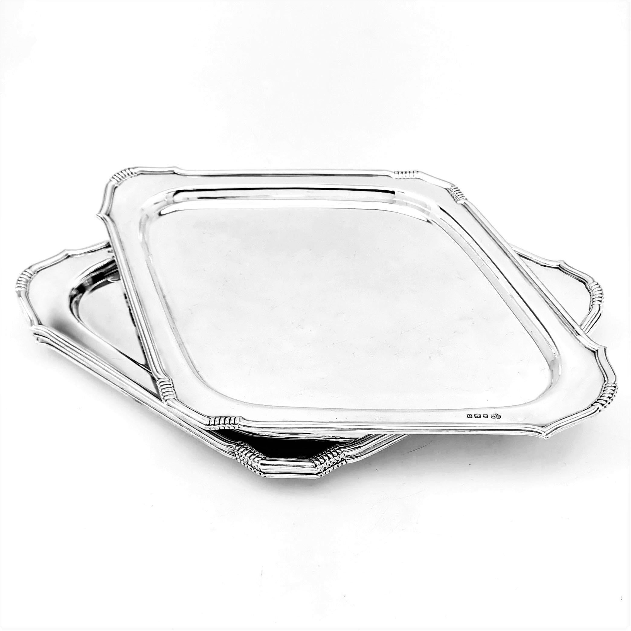 A set of four Art Deco solid Silver serving Platters, Trays or Salvers. These Art Deco Trays have an elegant, understated design. Each Platter is a lozenge shape and has decorative chased banding designs on the corners. These Trays are of excellent