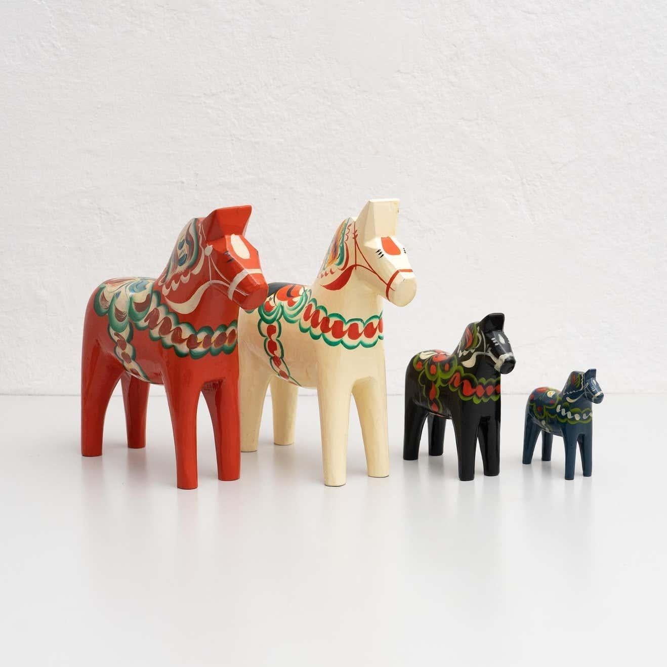 Set of 4 hand-painted Swedish wooden traditional Dala horse toy.    Designed by Nils Olsson in Sweden, circa 1960.  Materials:  Wood    In original condition, with minor wear consistent with age and use, preserving a beautiful patina.    Dimensions: