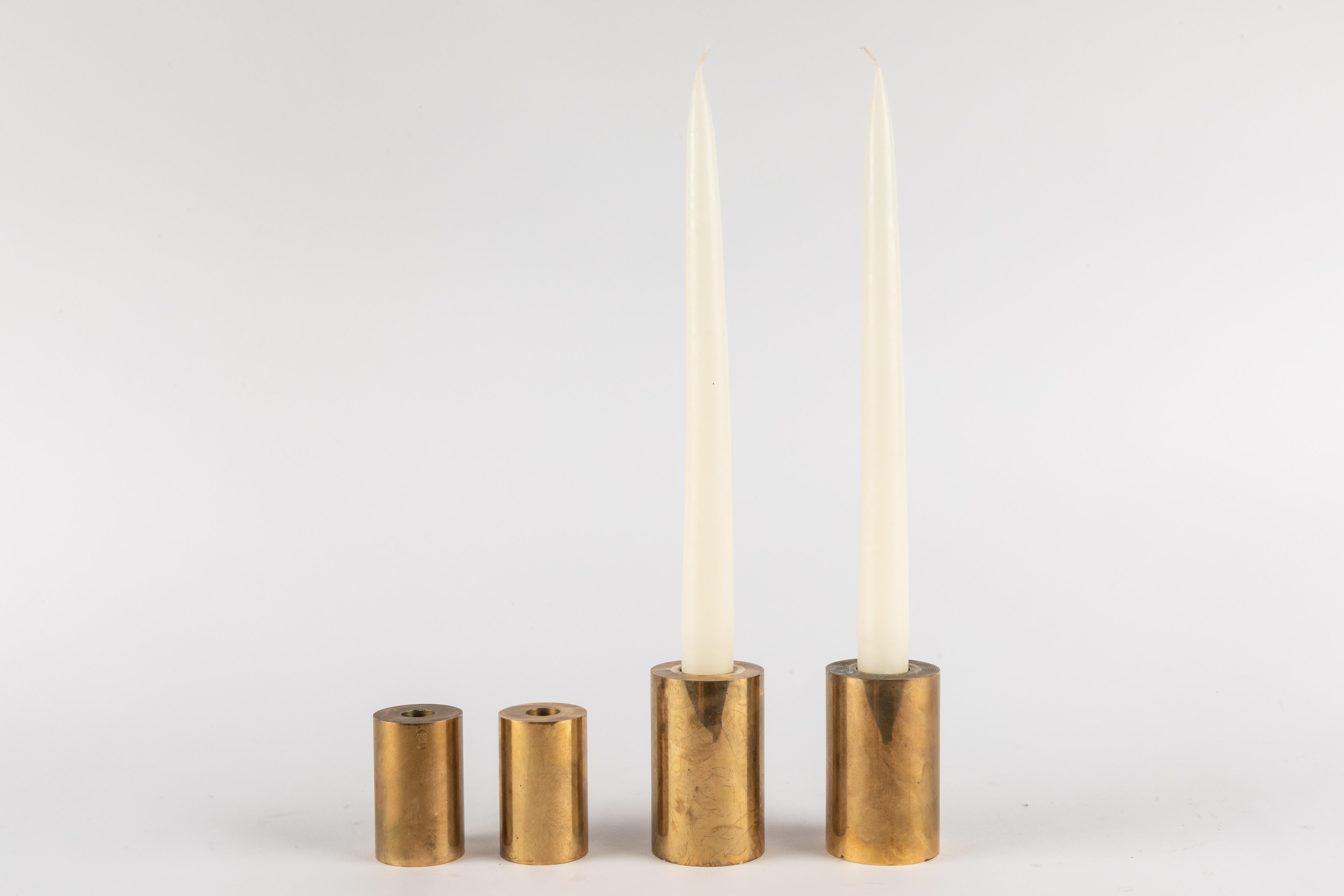 Set of 4 Swedish Metallslöjden Gusum brass candlesticks. One of his most noteworthy and iconic designs. Quintessentially Scandinavian modern in its execution and inherent aesthetics. Executed in solid cylindrical brass, this ultra refined design