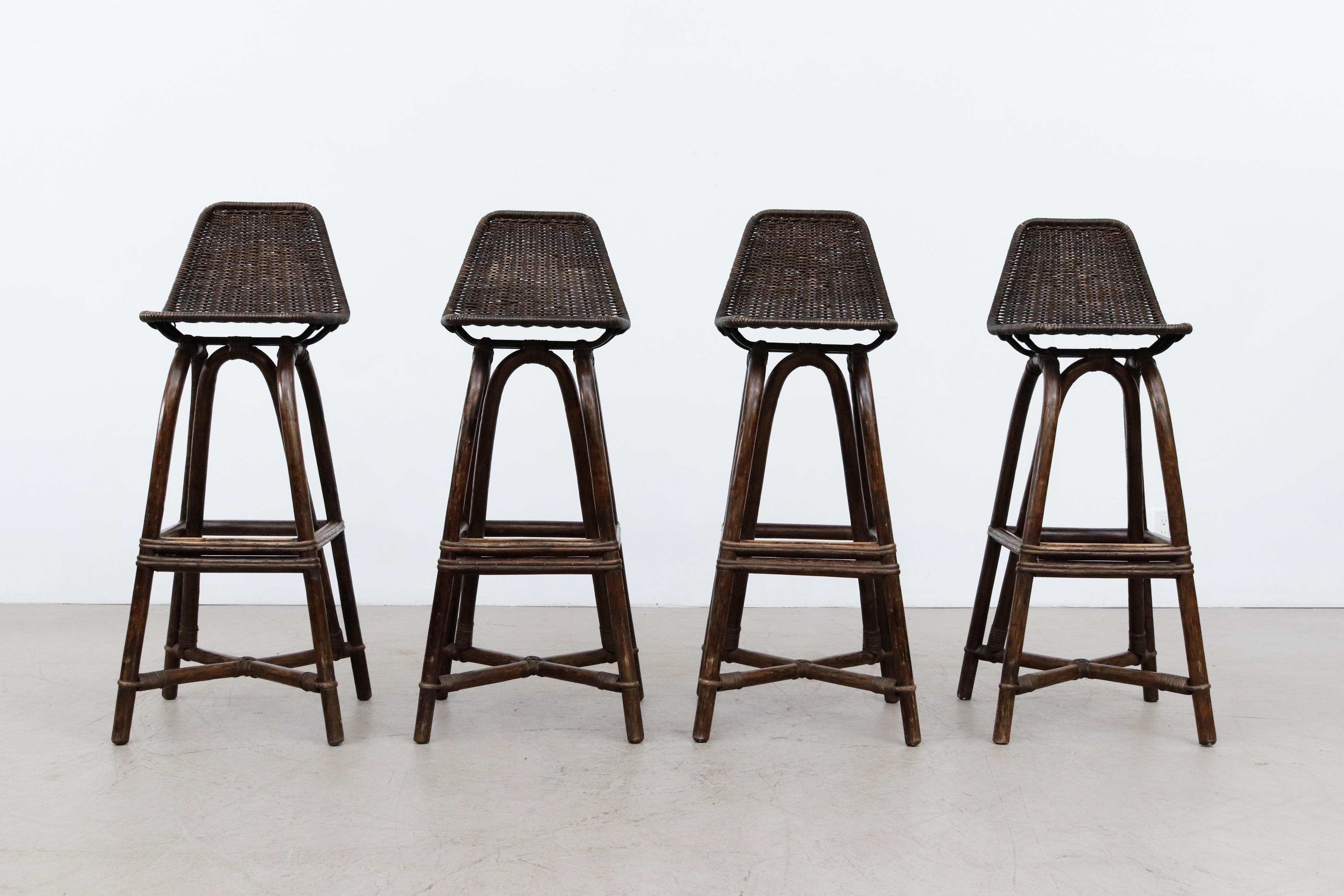 Set of 4 tall mid-century black stained bamboo bar stools inspired by Charlotte Perriand. In original condition with wear consistent with their age and use. Seat height is 35.25