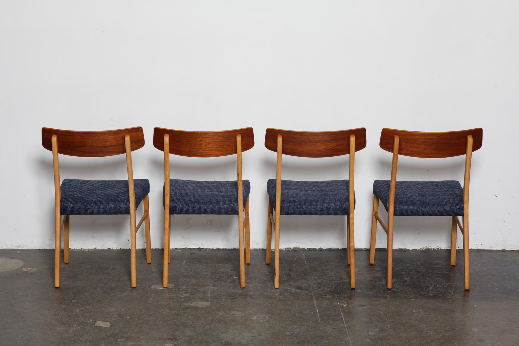Set of 4 teak bent back Danish dining chairs by Farstrup with beech legs. Newly refinished in a natural teak oil and reupholstered in a navy woven fabric.