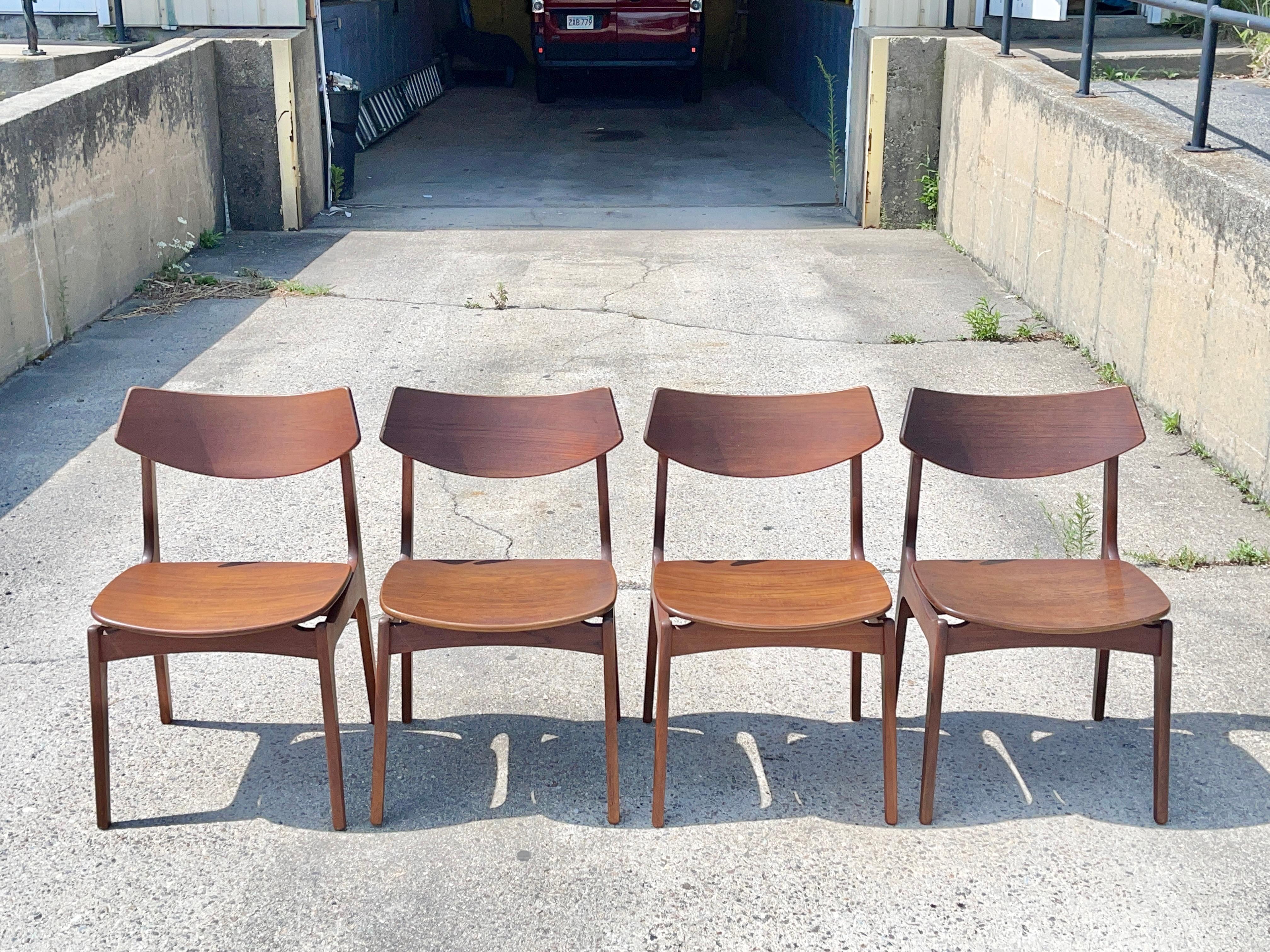 Set of four 1950’s dining chairs designed by Erik Buch for Funder-Schmidt & Madsen, Odense, Denmark. 
Two chairs have brand marks and two have paper labels on the underside. 
Molded open grain teak plywood floating seat, curved backrests, sculpted