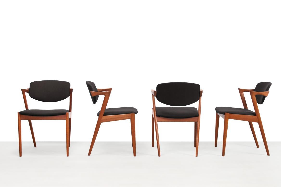 A beautiful set of 4 Danish design chairs designed by Kai Kristiansen for Schou Andersen. The chairs have model name number 42 and are made of solid teak wood and are upholstered in dark blue 'De Ploeg' (Dutch brand) furniture fabric. The fantastic