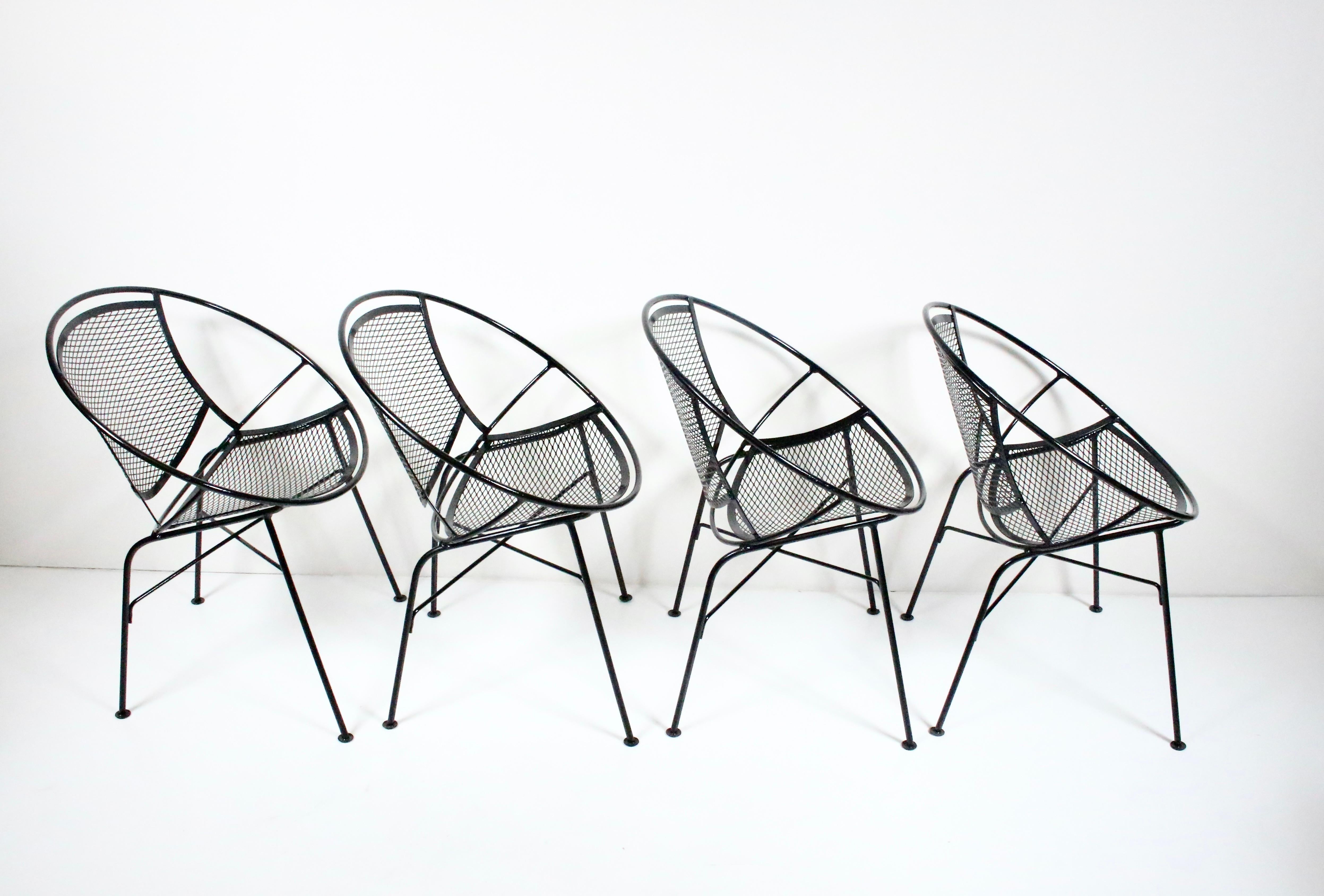 Original Maurizio Tempestini for Salterini set of four black radar dining armchairs. Featuring a sculpted sturdy hoop framework in black enameled wrought iron and sturdy wire mesh. Indoor outdoor seating. American Mid-Century Modern. Classic.