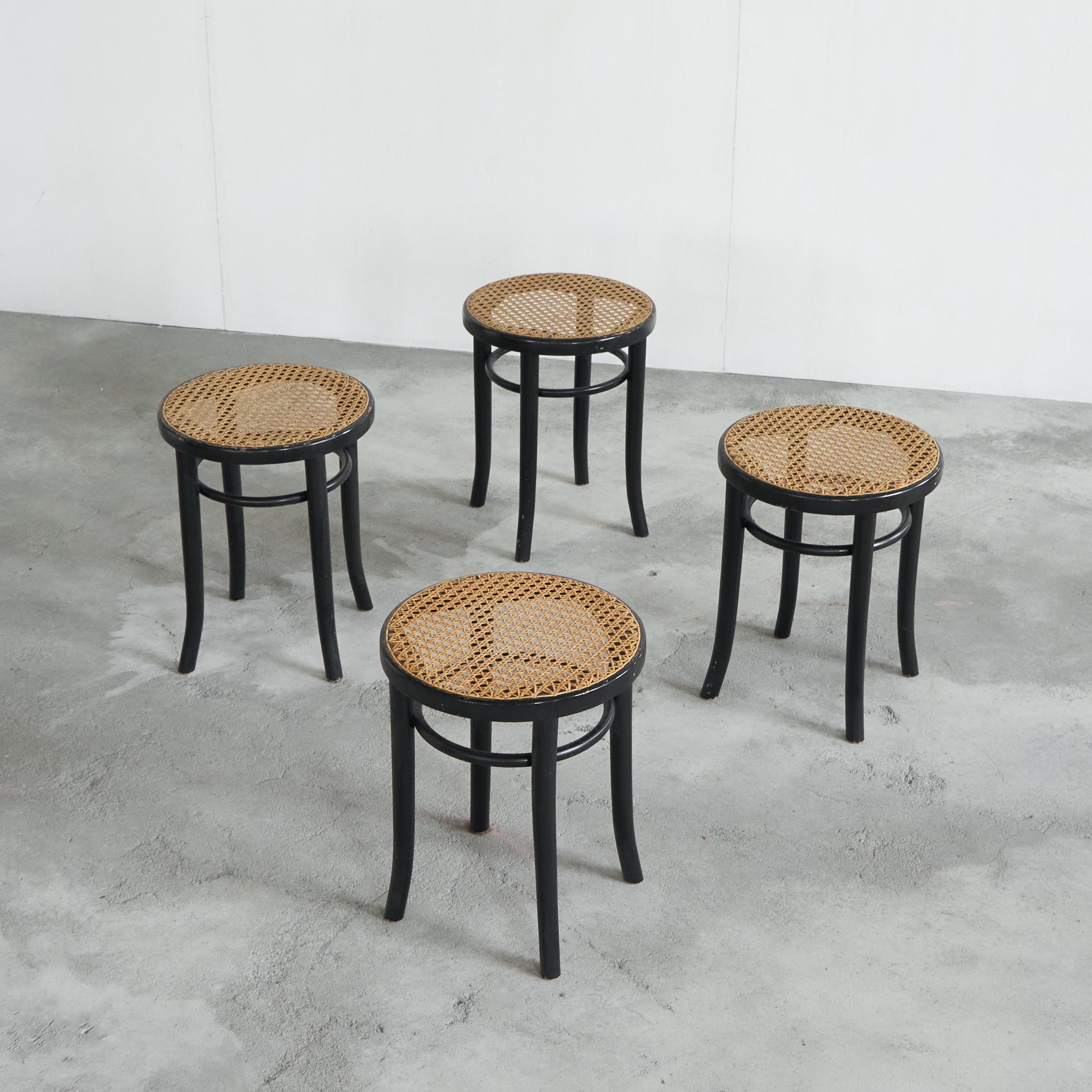 Voici un magnifique ensemble de tabourets de style Thonet en bois courbé laqué noir et sangles. Fabriqué en Europe dans les années 1970. 

Design très élégant et intemporel qui s'adapte à presque tous les styles d'intérieur. La laque noire contraste