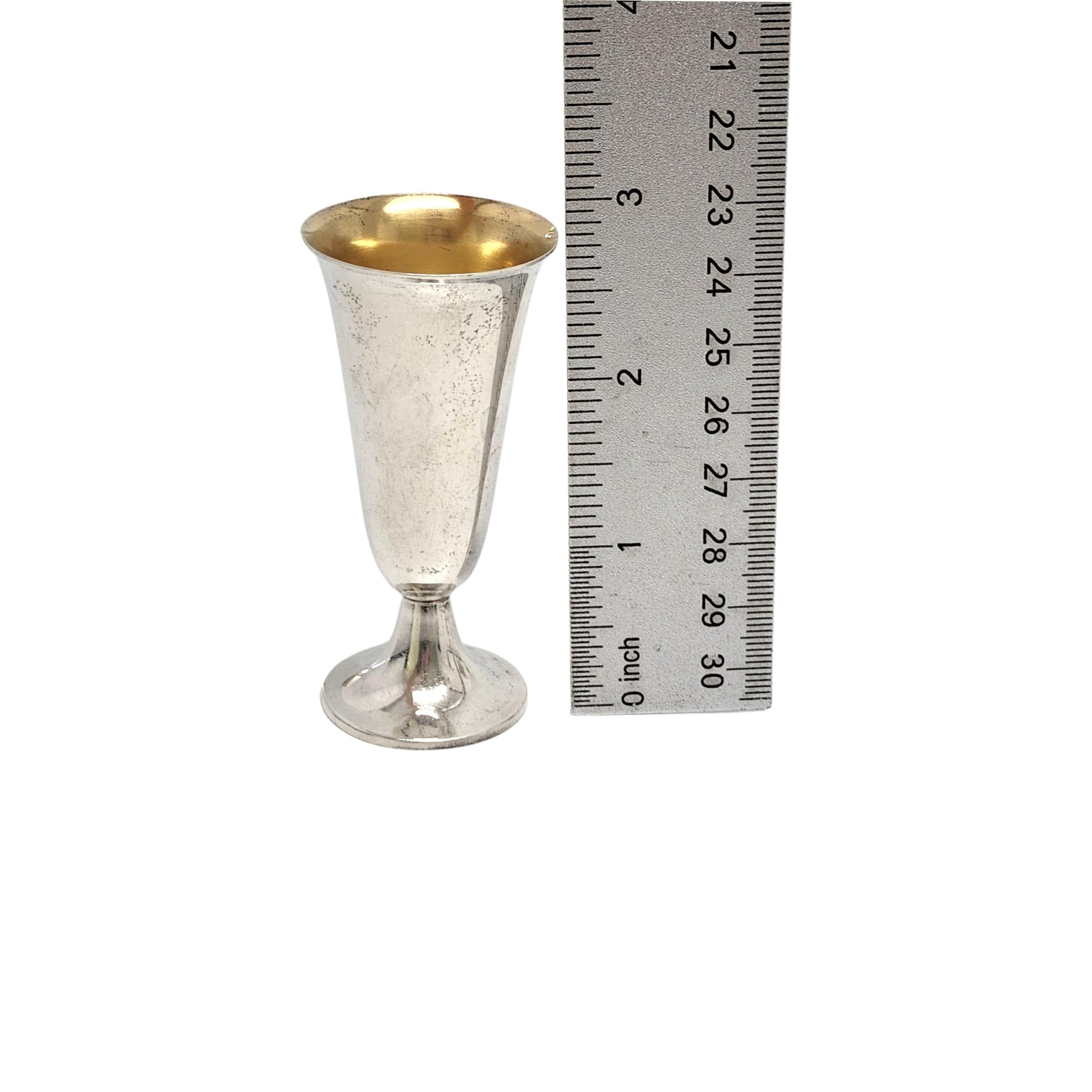Set of 4 sterling silver with gold wash interior cordial/shot cups by Tiffany & Co.

Simple and timeless elongated goblet design with bright gold wash interior. The L hallmark dates this pieces to manufacture under the directorship of William T