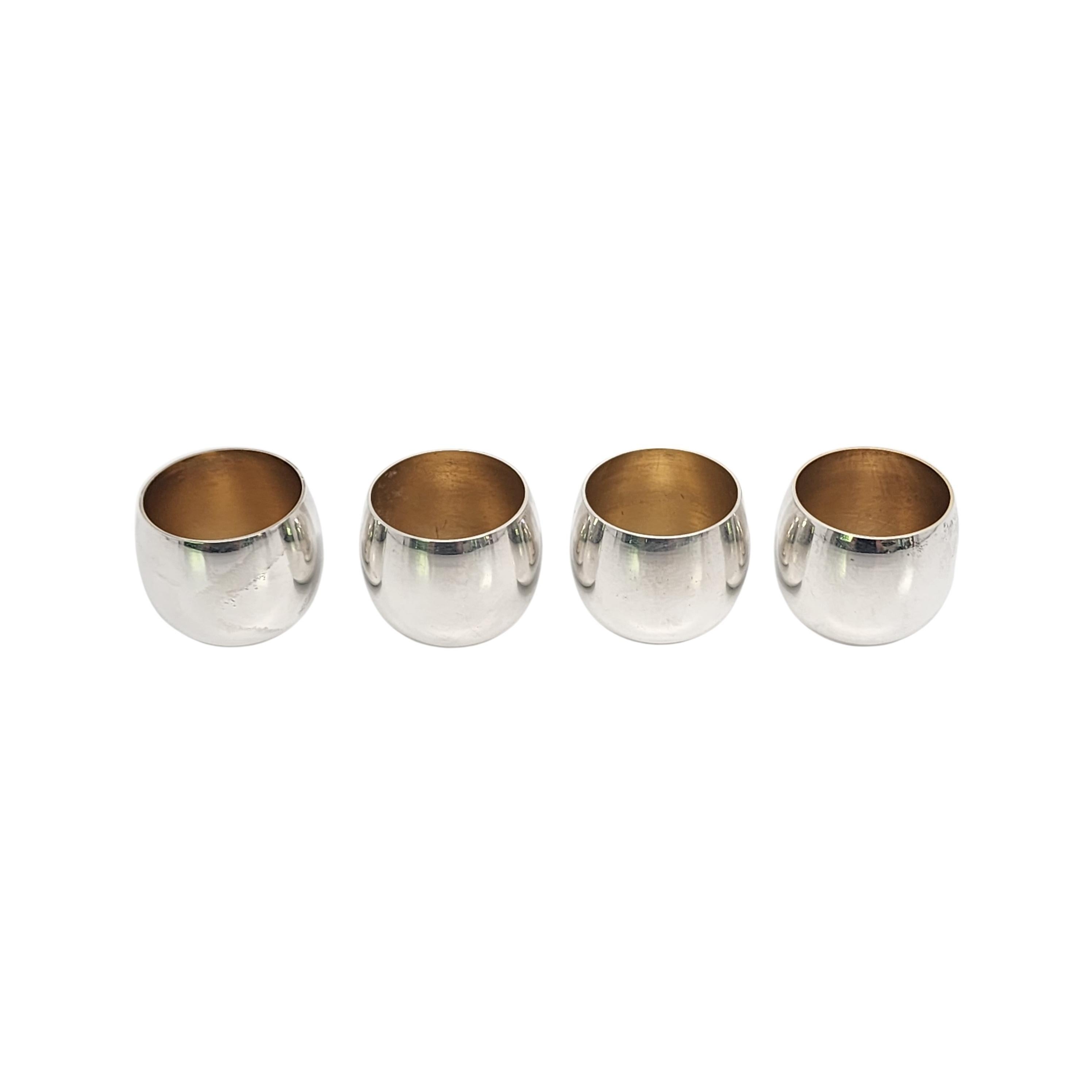 Set of 4 Tiffany & Co Makers sterling silver shot/cordial cups with pouches and box.

No monogram or engraving.

Round design with a smooth polished finish and a gold wash interior. Includes 4 vintage pouches and red Tiffany & Co vintage cardboard