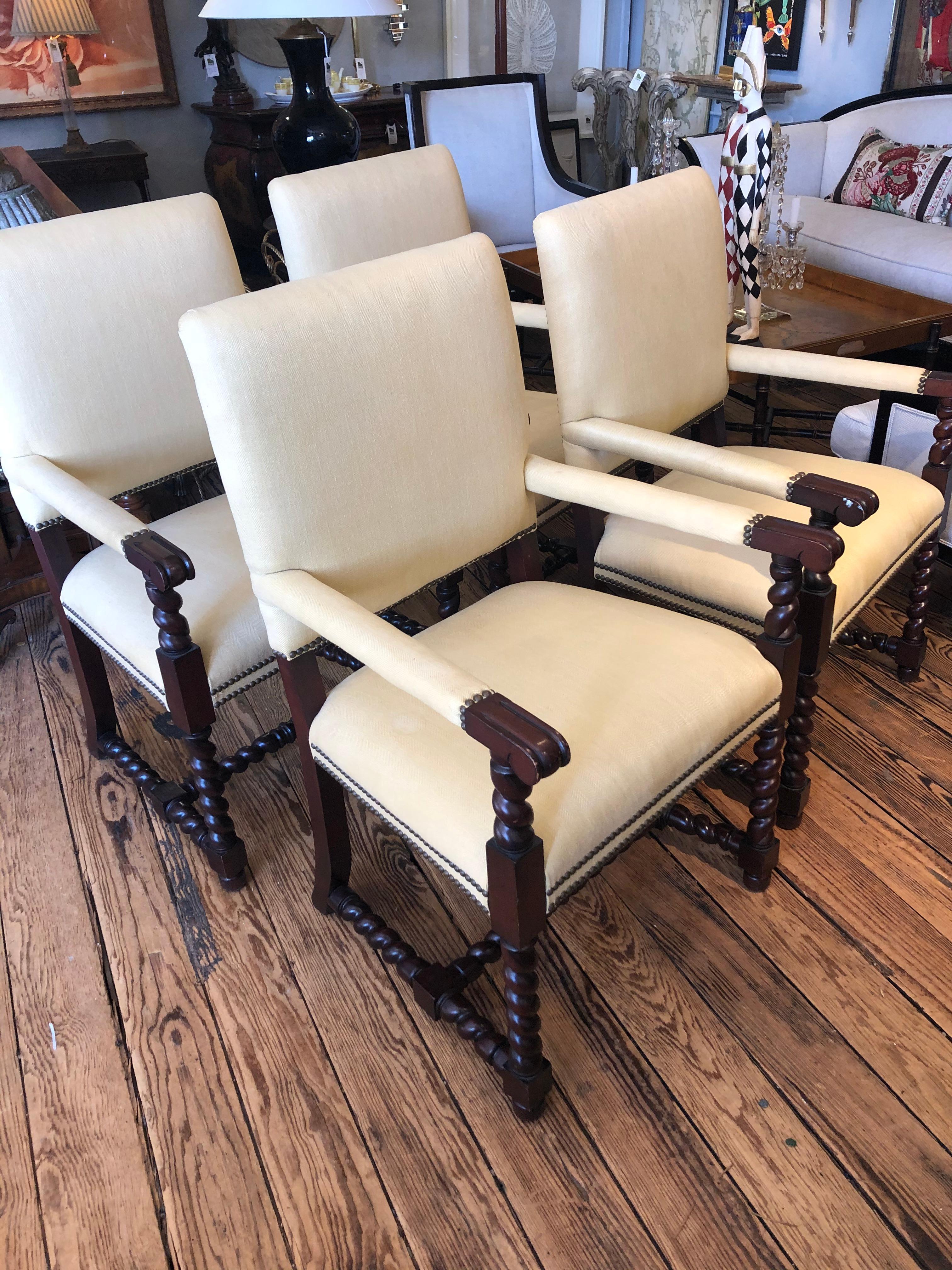 Classic set of 4 Tudor style mahogany armchairs having pale yellow silk upholstery, barley twist arm supports, legs and stretchers and brass nailhead trim. Comfortable and solid chairs, but could use updated upholstery.
Great as large dining