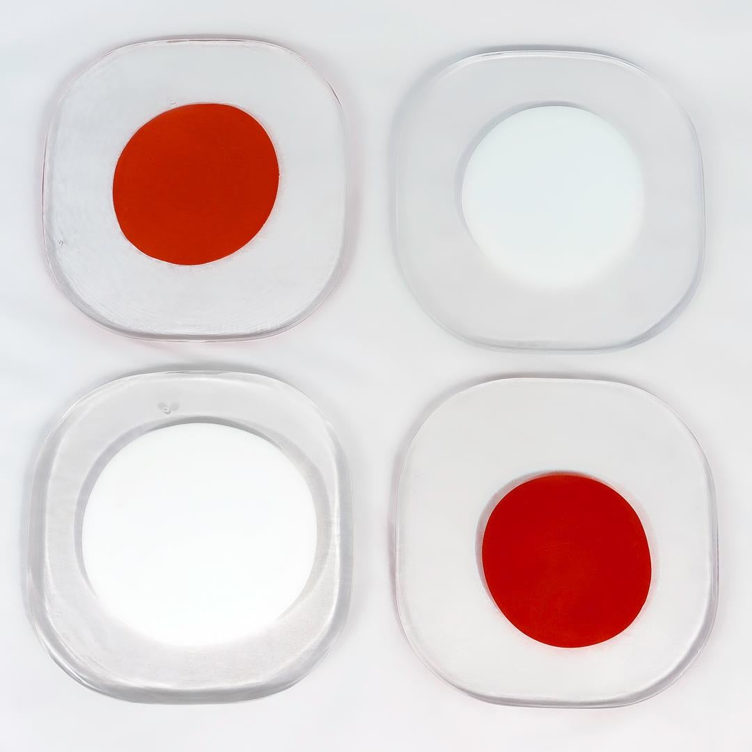 A very fine set of 4 Venini glass plates.

Design attributed to Pierre Cardin.

The group comprising 4 thick, square glass plates with rounded corners and a large red or white dot to each center.

Designed ca. 1970. These plates issued in the