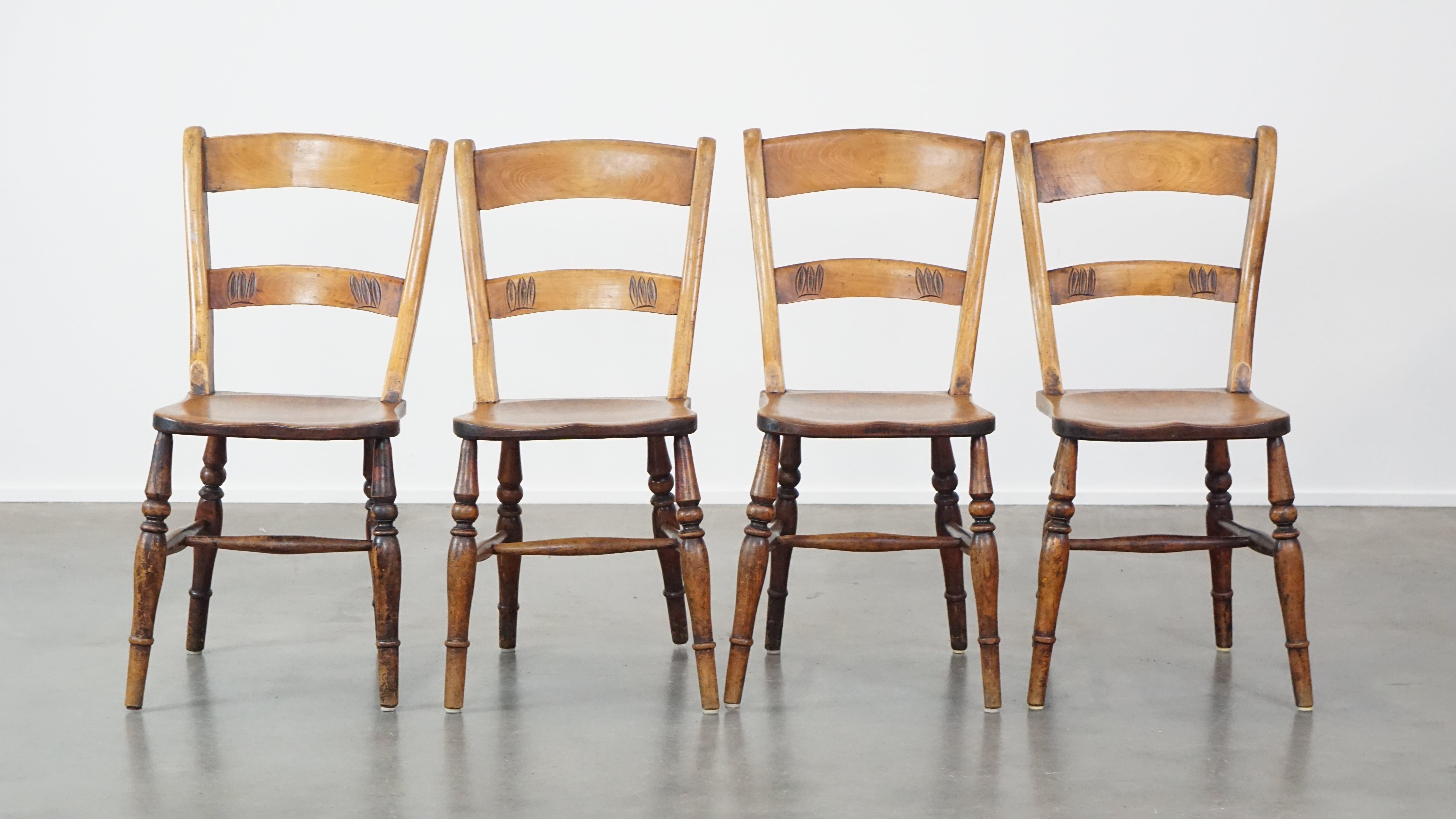 Set of 4 very charming English antique country dining chairs with a beautiful patina. This set of antique gems features exquisite wood carving on the backrest. Chairs like these are not only perfect for pairing with an antique table, but they also