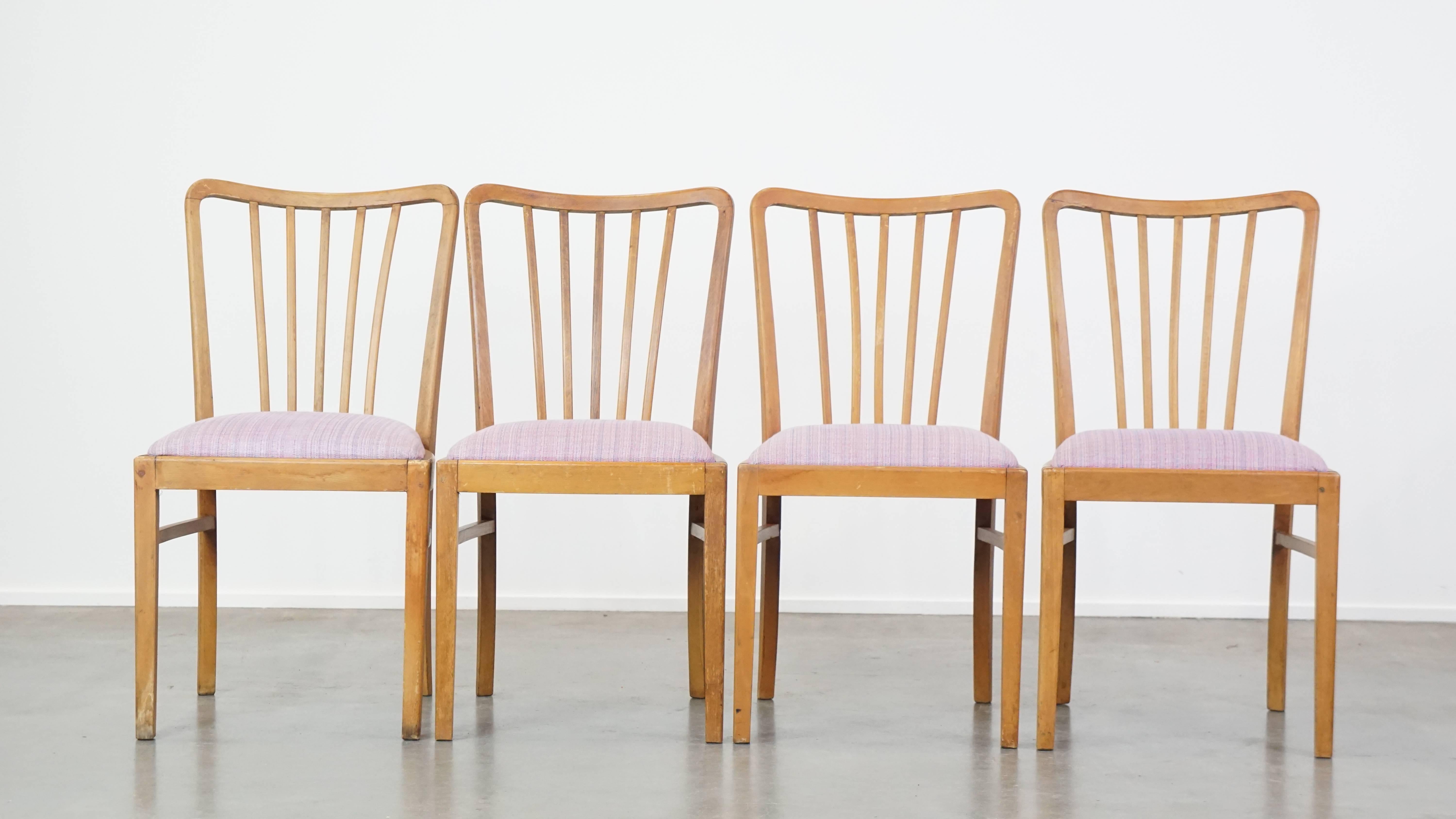 Questo set di 4 sedie da pranzo vintage degli anni '70 emana calma, fascino e intimità. Presentano una struttura in legno con schienale a fuso e sedute in tessuto. A causa degli anni di utilizzo, presentano normali segni di usura e strutturalmente