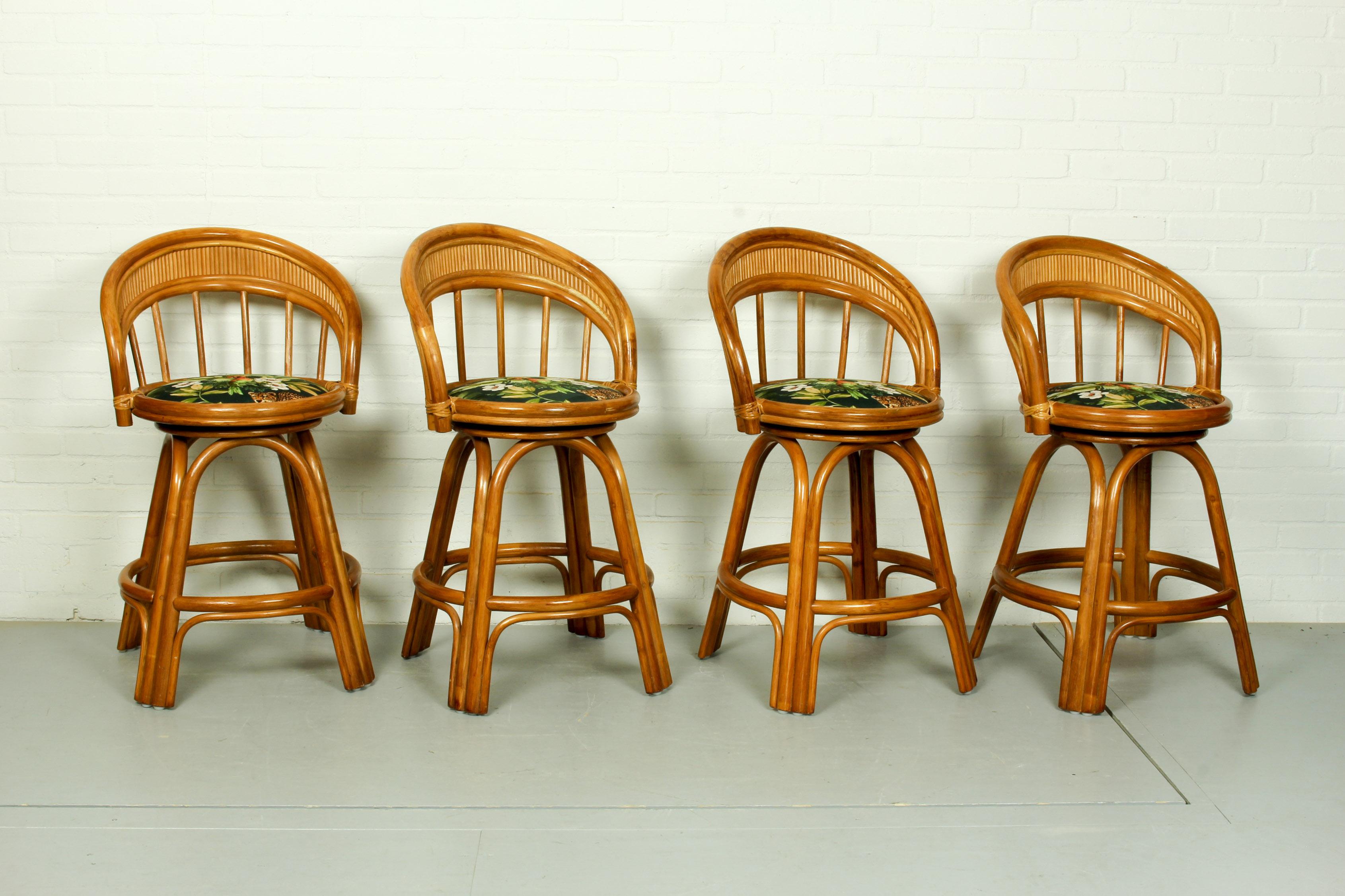 Set of 4 pivoting bar stools, produced circa 1970. Bamboo frame and velour fabric seat with exotic plants and birds. In good condition. 

Dimensions: 92cm H, 60cm W, 60cm D. Seating height 60cm.
 