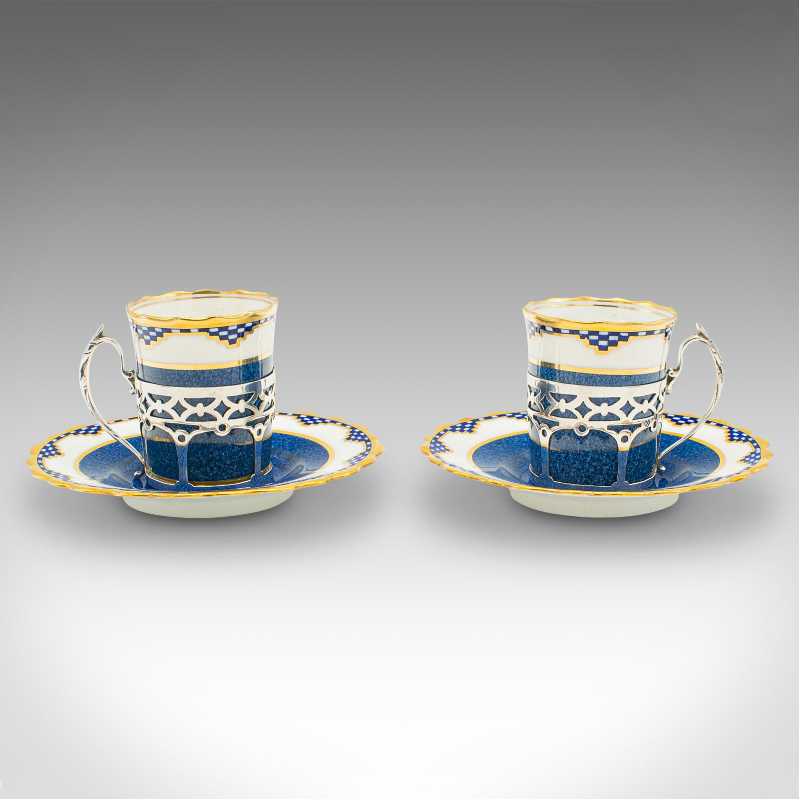 This is a set of 4 vintage cups and saucers. An English, ceramic and hallmarked silver coffee can by Aynsley, dating to the early 20th century, circa 1930.

Wonderfully petite with striking silver handles
Displaying a desirable aged patina and in
