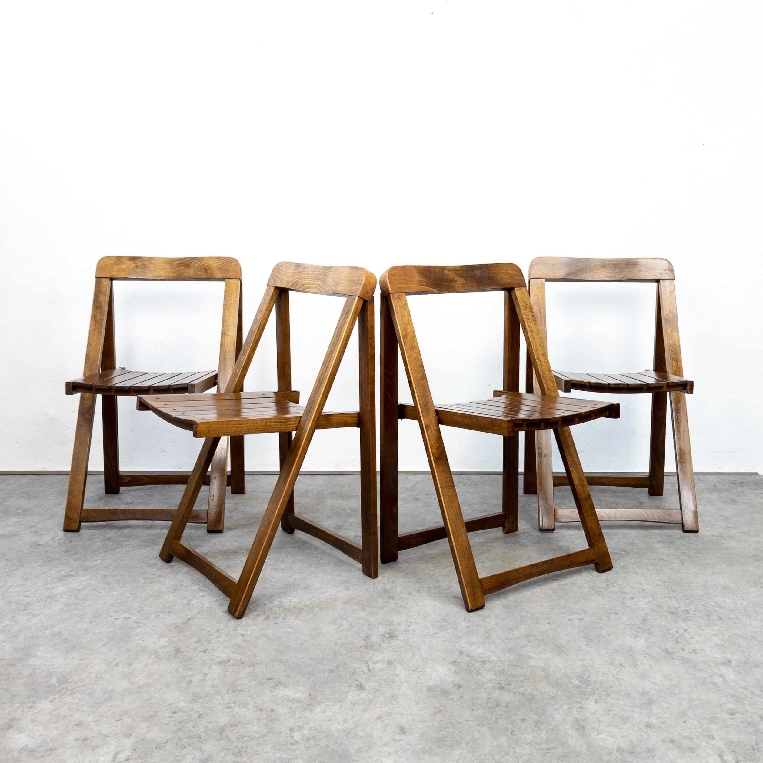 Set of four folding chairs in beech wood. In very good original condition with some traces of wear and age. Beautiful patina. Structurally sound.