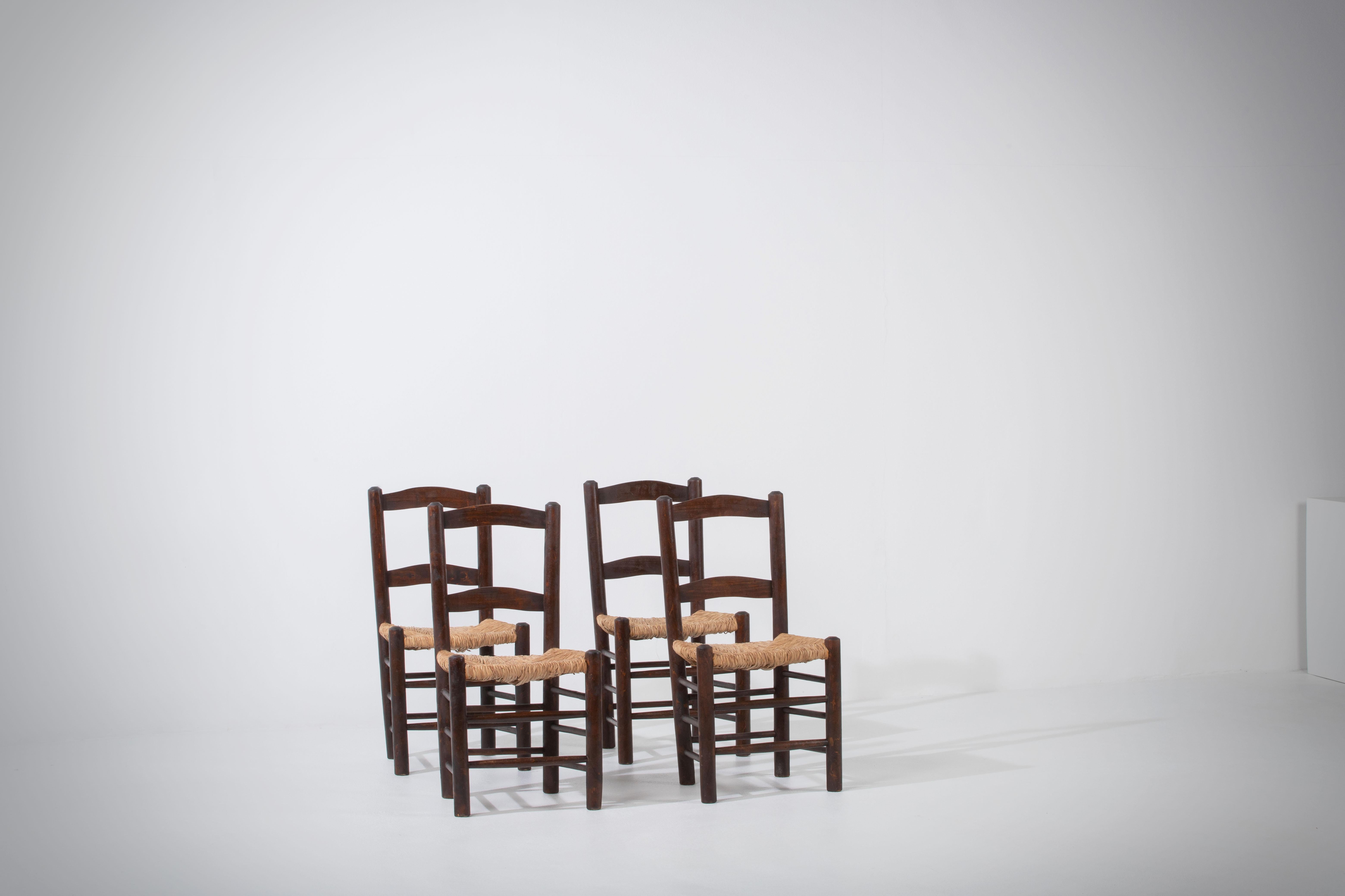 Wir präsentieren eine Reihe von Stühlen aus Eiche und Binsen, inspiriert vom ikonischen Stil der berühmten französischen Designerin Charlotte Perriand. Diese um 1960 in Frankreich gefertigten Stühle verkörpern die zeitlose Eleganz und Handwerkskunst