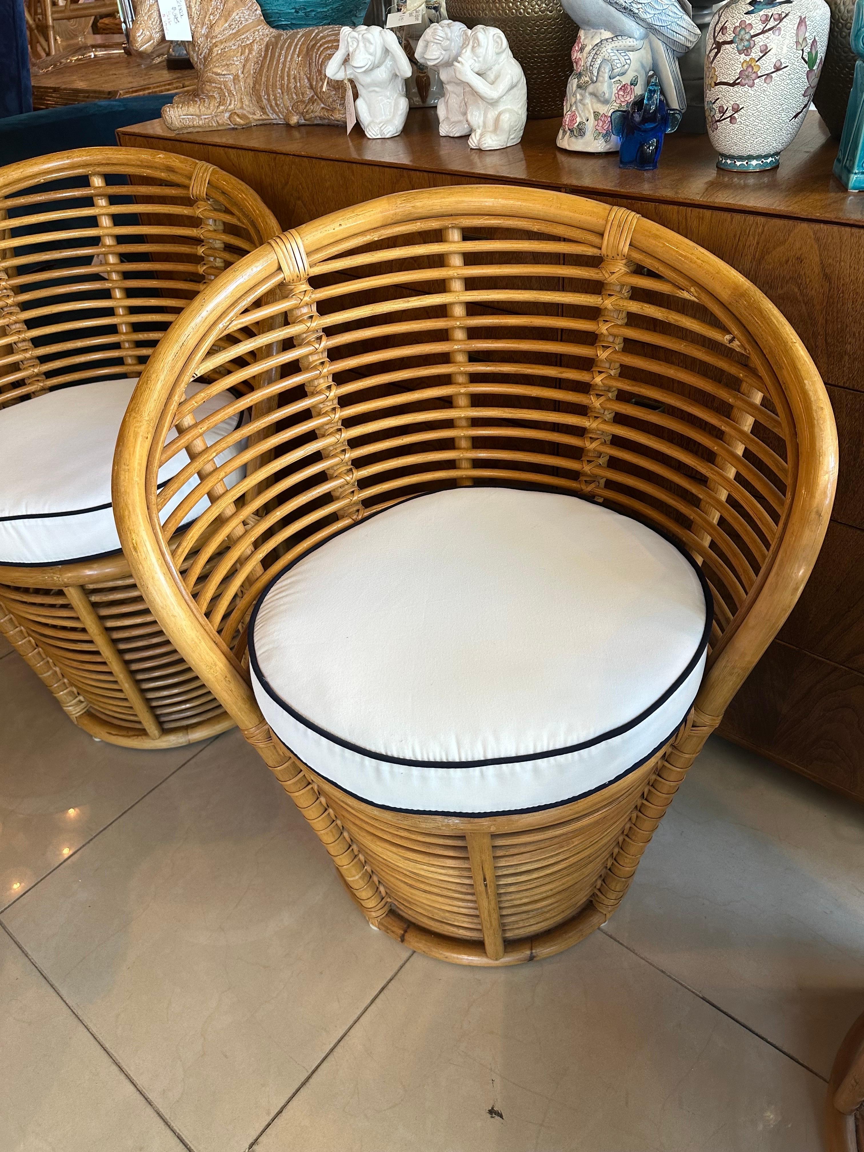 Lovely vintage set of 4 French rattan barrel curved dining chairs. New custom cushions with Sunbrella white and navy welt, ties on back. reversible. Chairs may have minor imperfections to the original rattan finish. Some minor stretching to one of