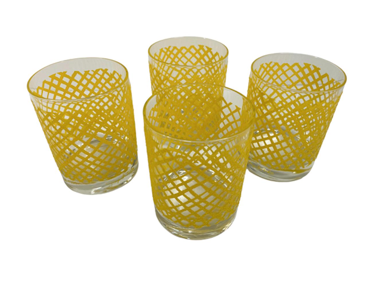 Four Georges Briard rocks glasses with raised and textured irregular yellow net pattern with a non-slip surface.