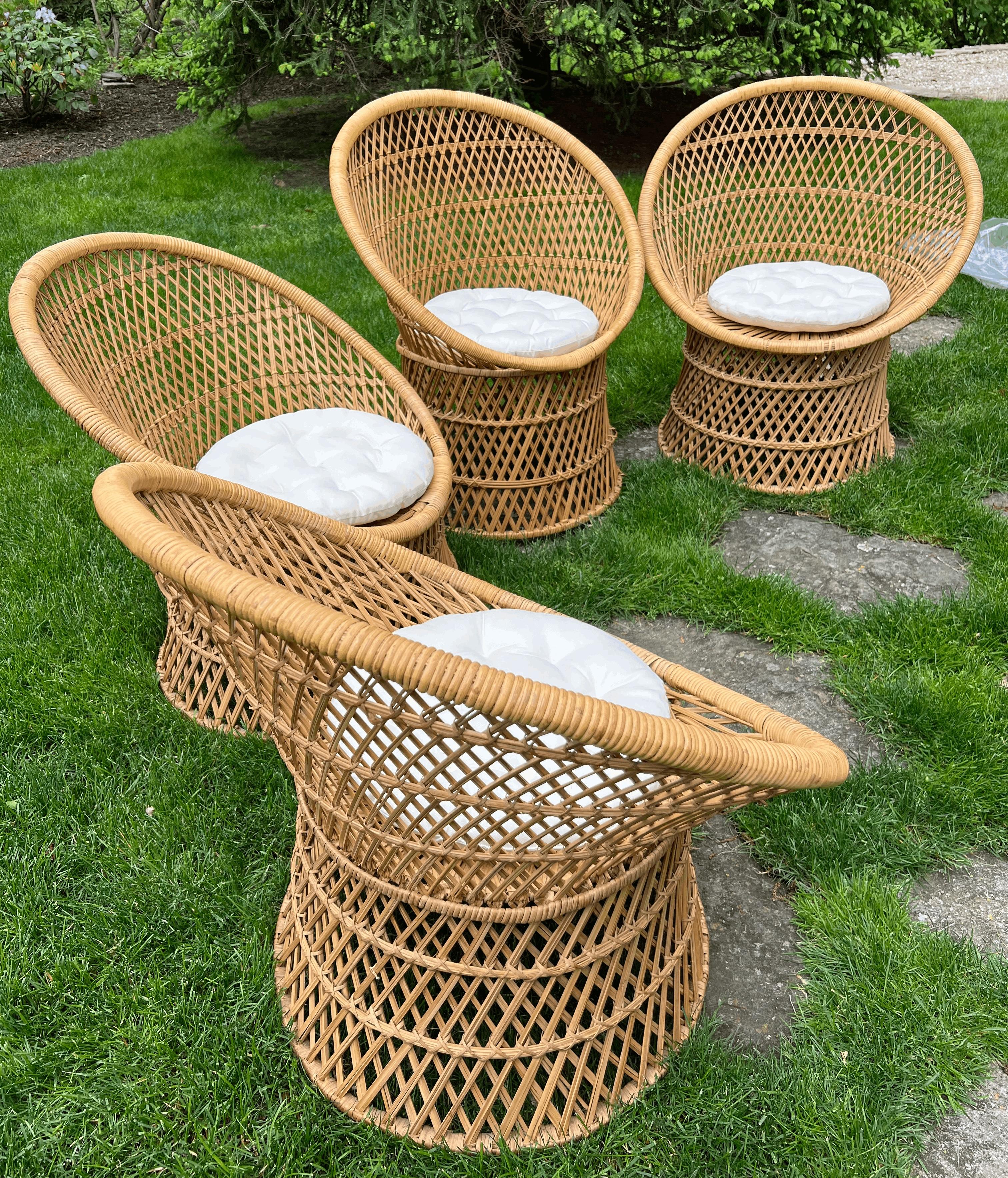 A charming set of four vintage wicker chairs, each handwoven with subtle variations that speak to their artisan craftsmanship. These low-profile lounge chairs feature gently curved barrel backs and flared bases, creating an airy yet sculptural
