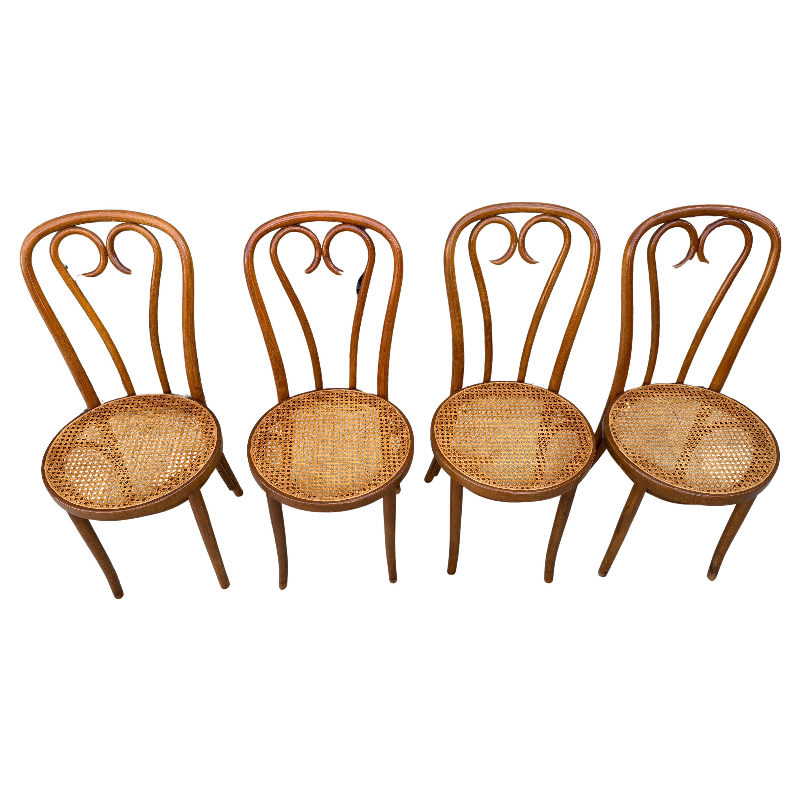 Set of 4 Mid century vintage cane seat cafe chairs by Thonet. Sweetheart chairs. They are in original condition with nice patina. The light golden brown Walnut wood has been oiled showing normal wear and ready for use. All Cane has been replaced and