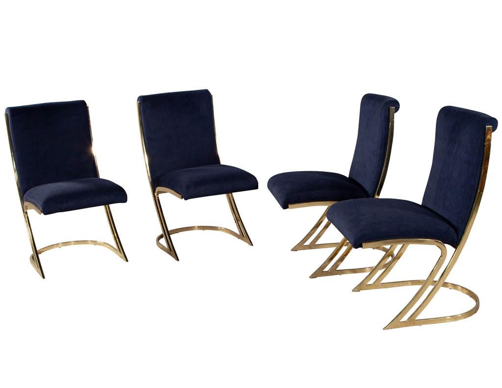 Set of 4 Vintage Mid-Century Modern brass dining chairs. Solid mirror brass frames upholstered in a navy velvet. Brass frames are all original, wear consistent with age and use.

Price includes complimentary scheduled curb side delivery service to