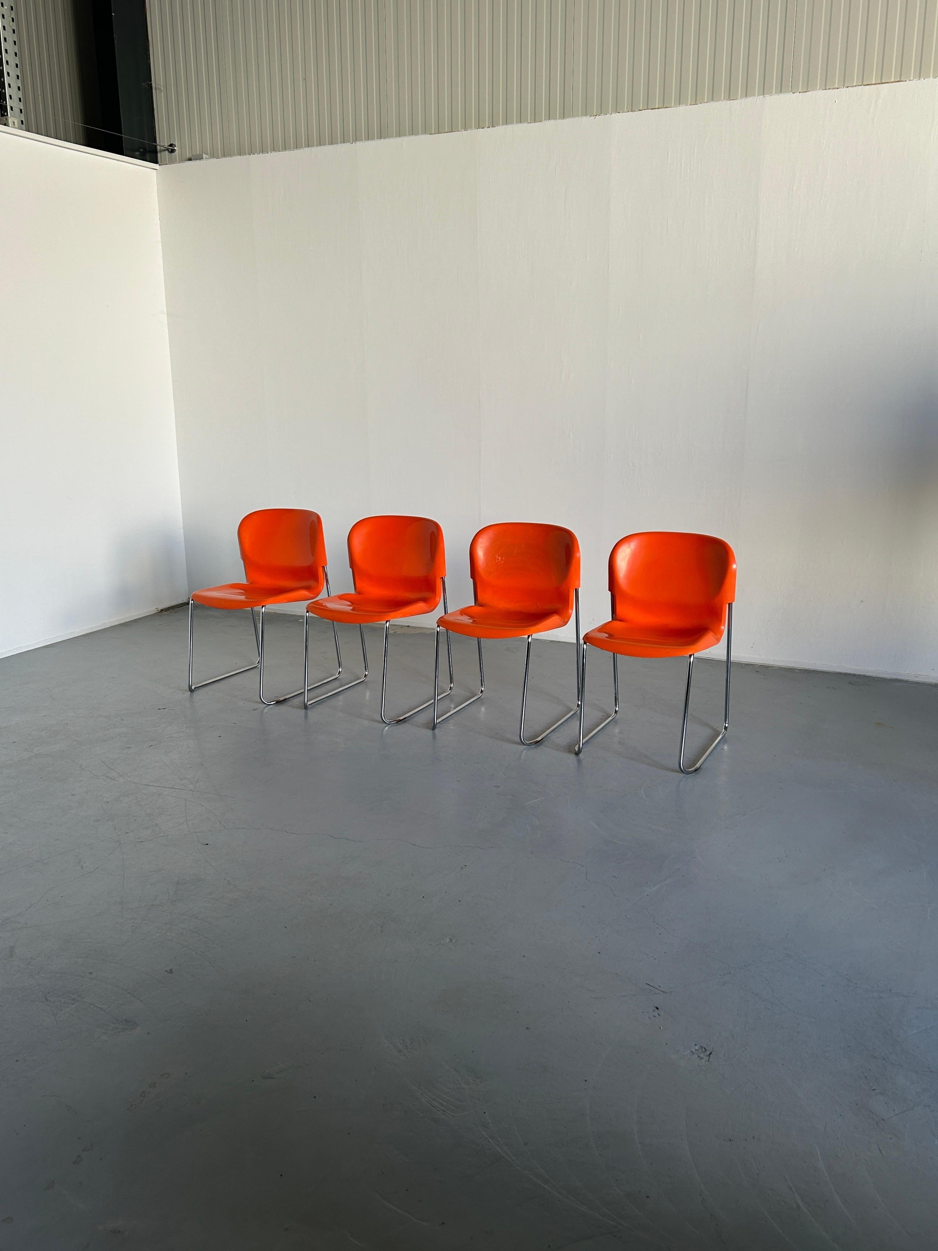 Set of four brightly colored pair of SM 400 Swing chairs designed in the 1970s by Gerd Lange for Drabert, a West German furniture maker. Orange molded plastic seats sit on a chrome frame that allows for easy stacking for storage.
Produced in West