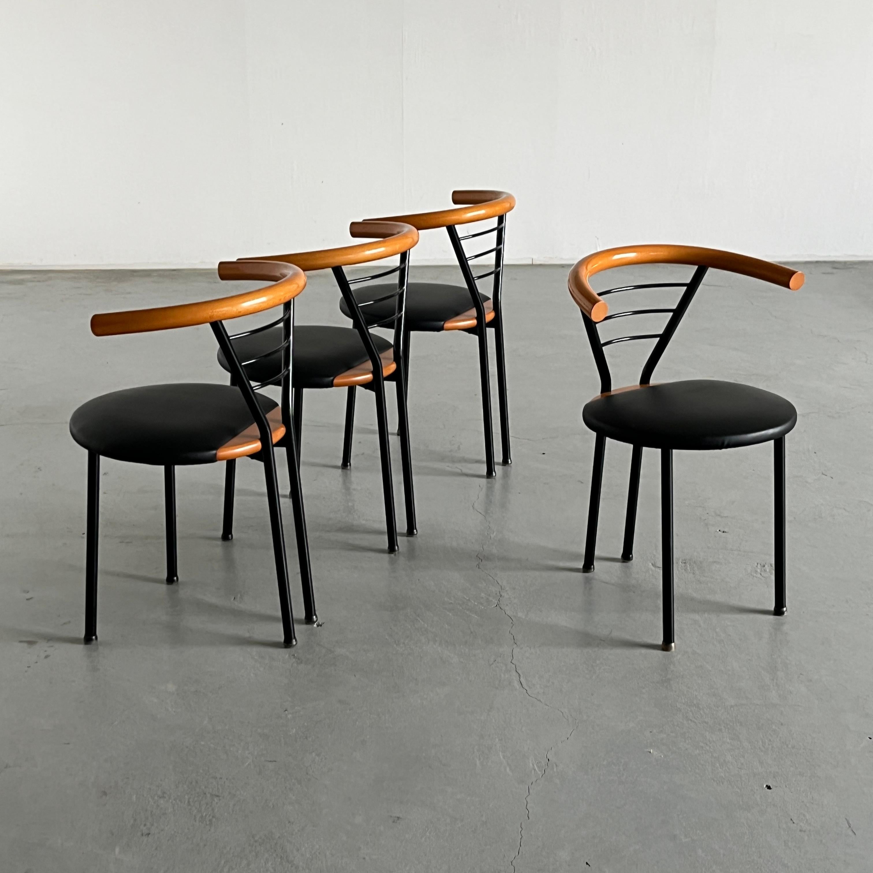 Set di quattro poltrone vintage postmoderne con rivestimento in ecopelle nera, struttura in metallo nero e dettagli dello schienale/bracciolo e della seduta in legno naturale.
Ricorda il design postmoderno dello stile Memphis Milano.

Prodotto in