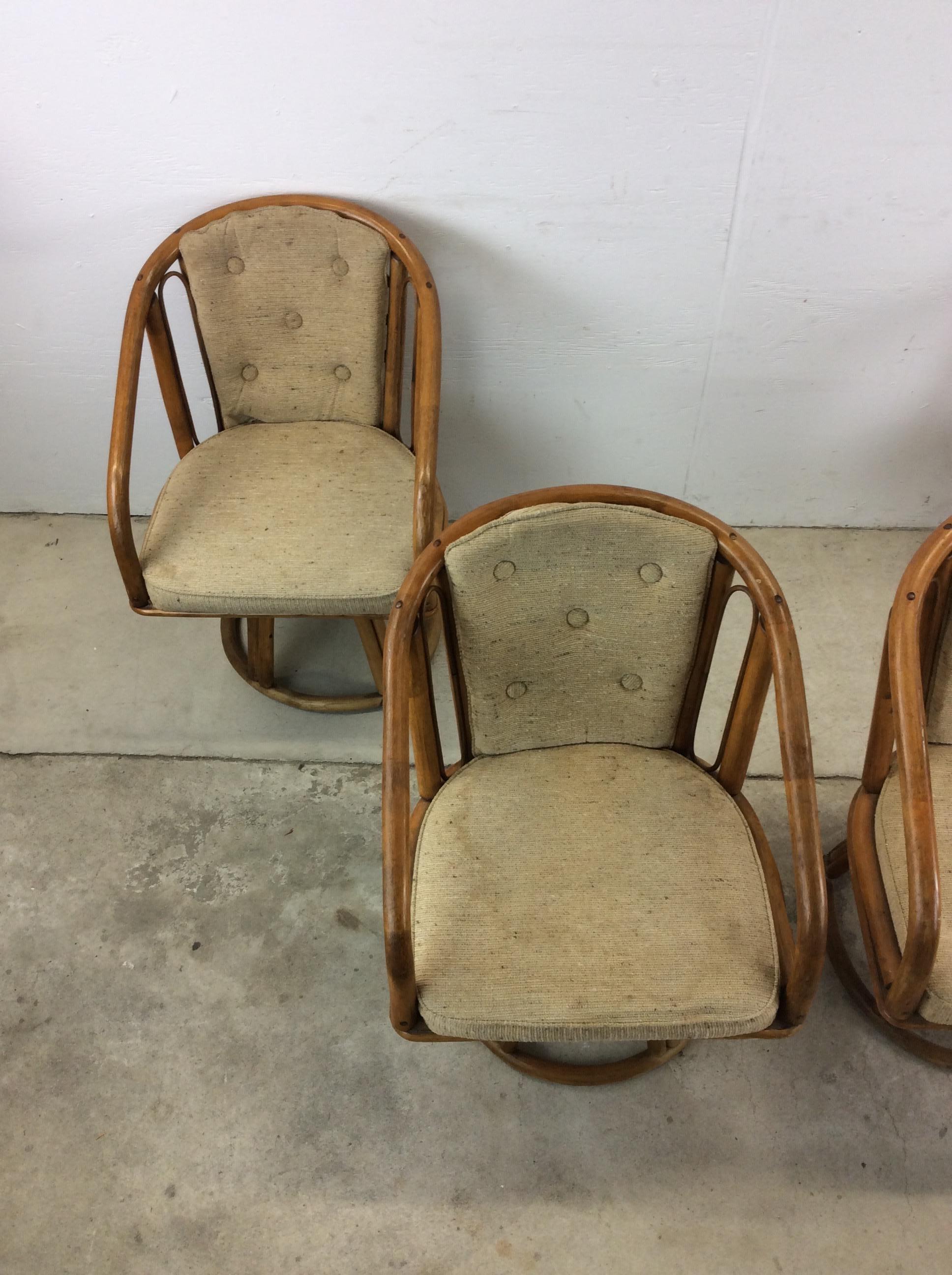 This vintage set of four kitchen chairs features solid rattan construction, original finish, vintage upholstery including tufted seat back, and unique swivel pedestal base.

Matching glass top table with rattan base available separately.