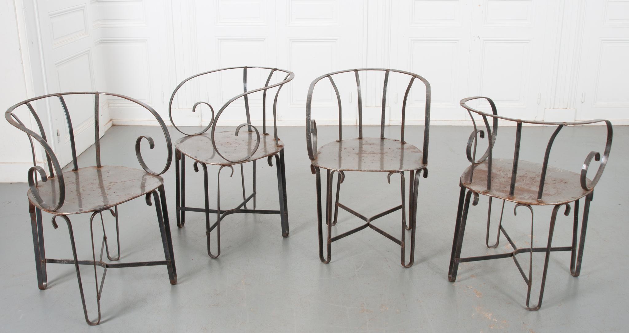 A very attractive set of four chairs from France with a mid-century design. Scrolling arms and shaped backs attach to a wide, flat seat. A pierced design of a six point star on the seat bottoms add a whimsical touch to these sturdy chairs.