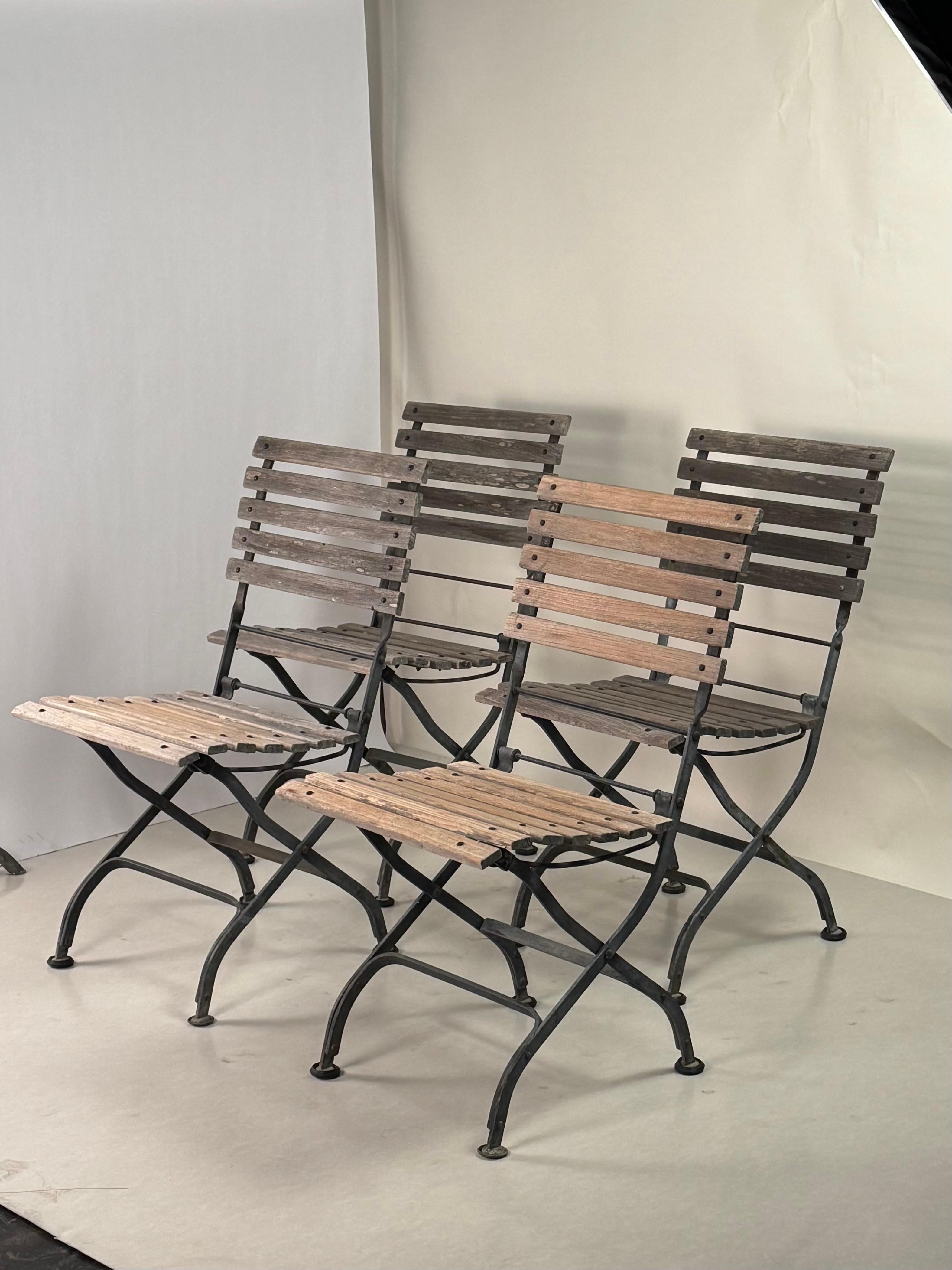 Juego de 4 sillas de jardín plegables de teca vintage.

Robustas estructuras de acero galvanizado con asientos y respaldos de listones de teca envejecida.

Se pliegan para guardarlos fácilmente.