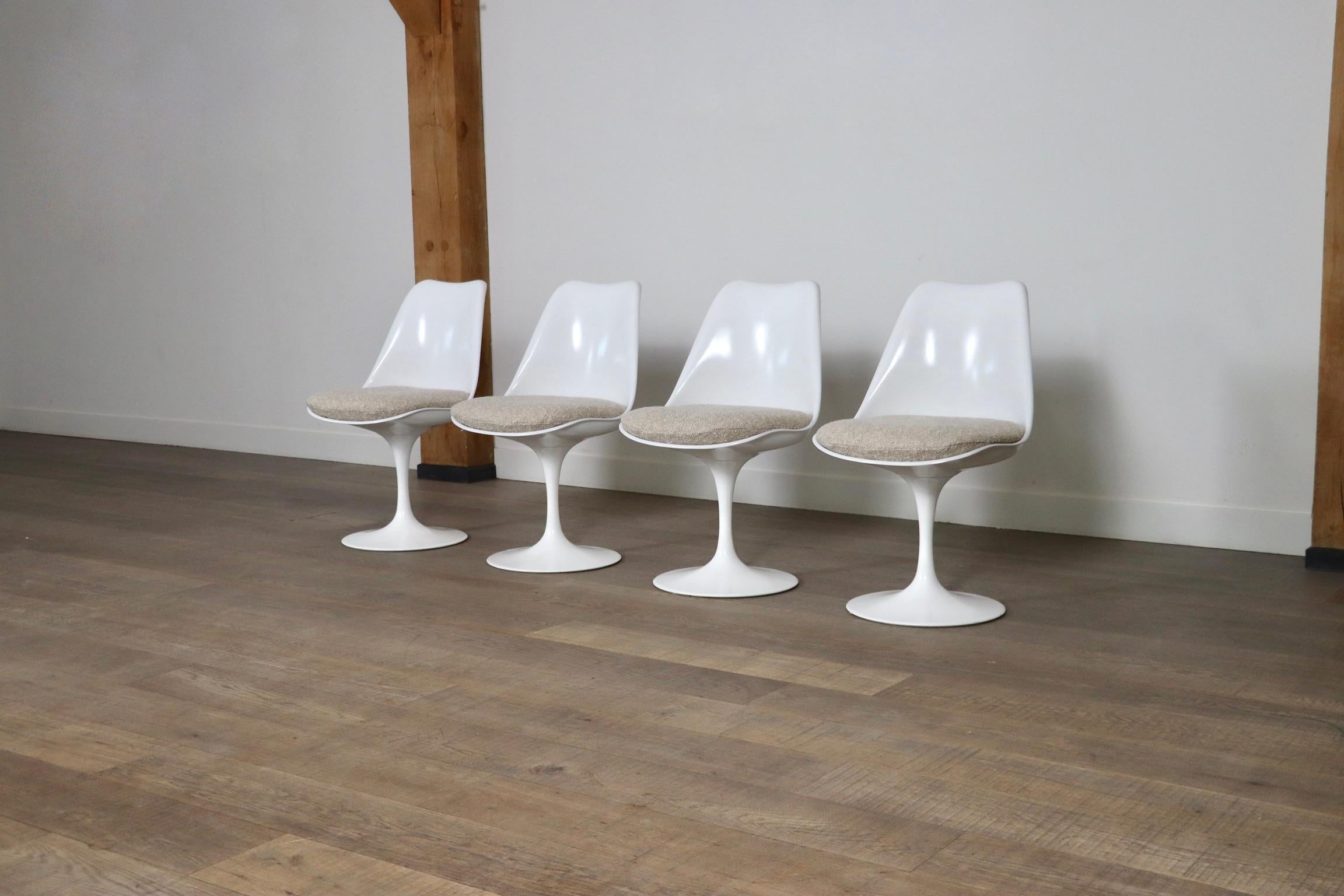 Amazing set of 4 Tulip chairs in beige bouclé by great designer Eero Saarinen, created in 1956. This particular set has four fixed chairs with newly upholstered seating cushions in a nice beige bouclé fabric. The covers are removable to clean them