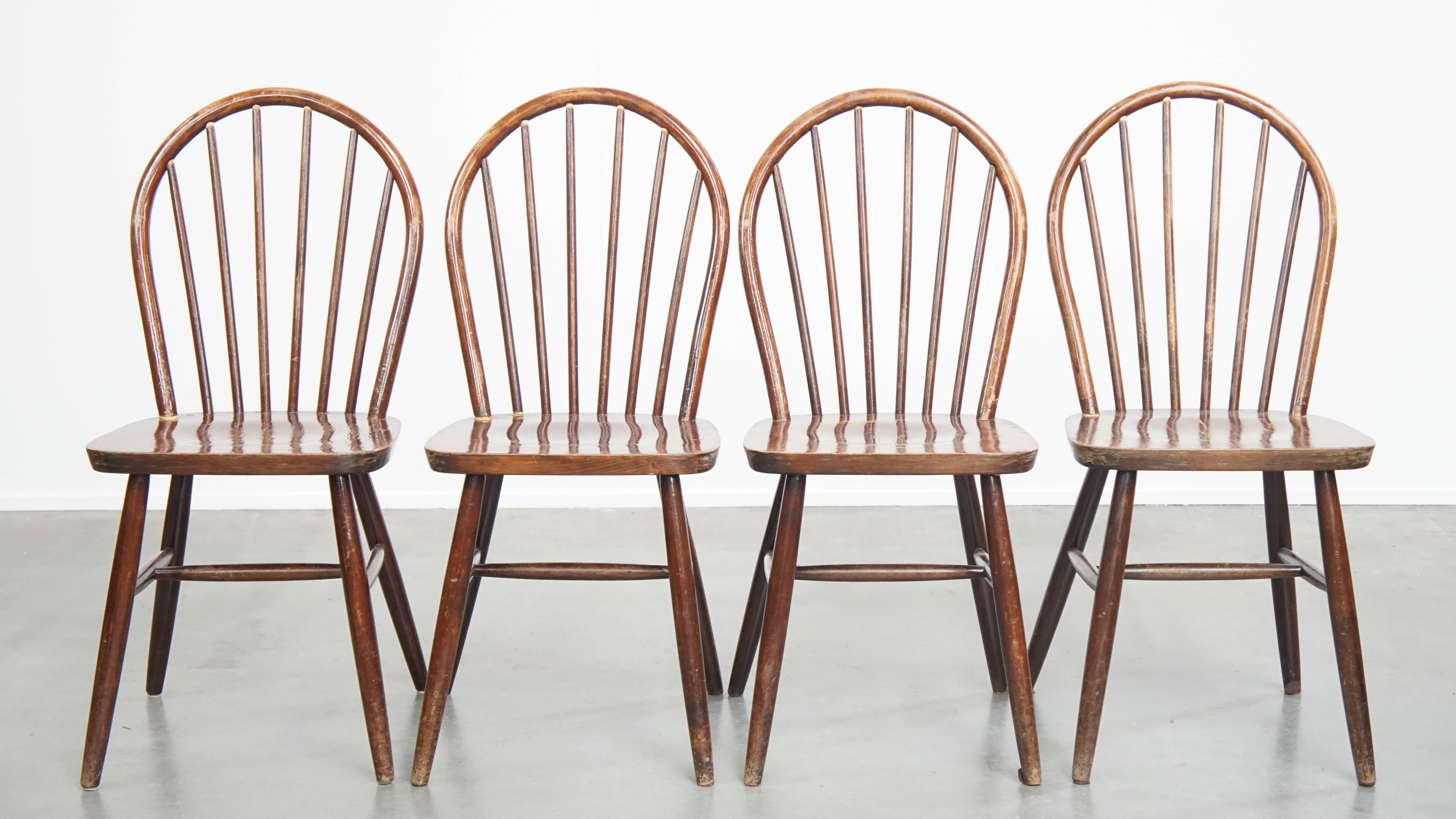 Offered here is this set of 4 vintage wooden spindle Windsor chairs from the 1970s in English style. These wonderful vintage Windsor chairs from the 1970s are not only perfect for use in a home environment, but they also work beautifully in