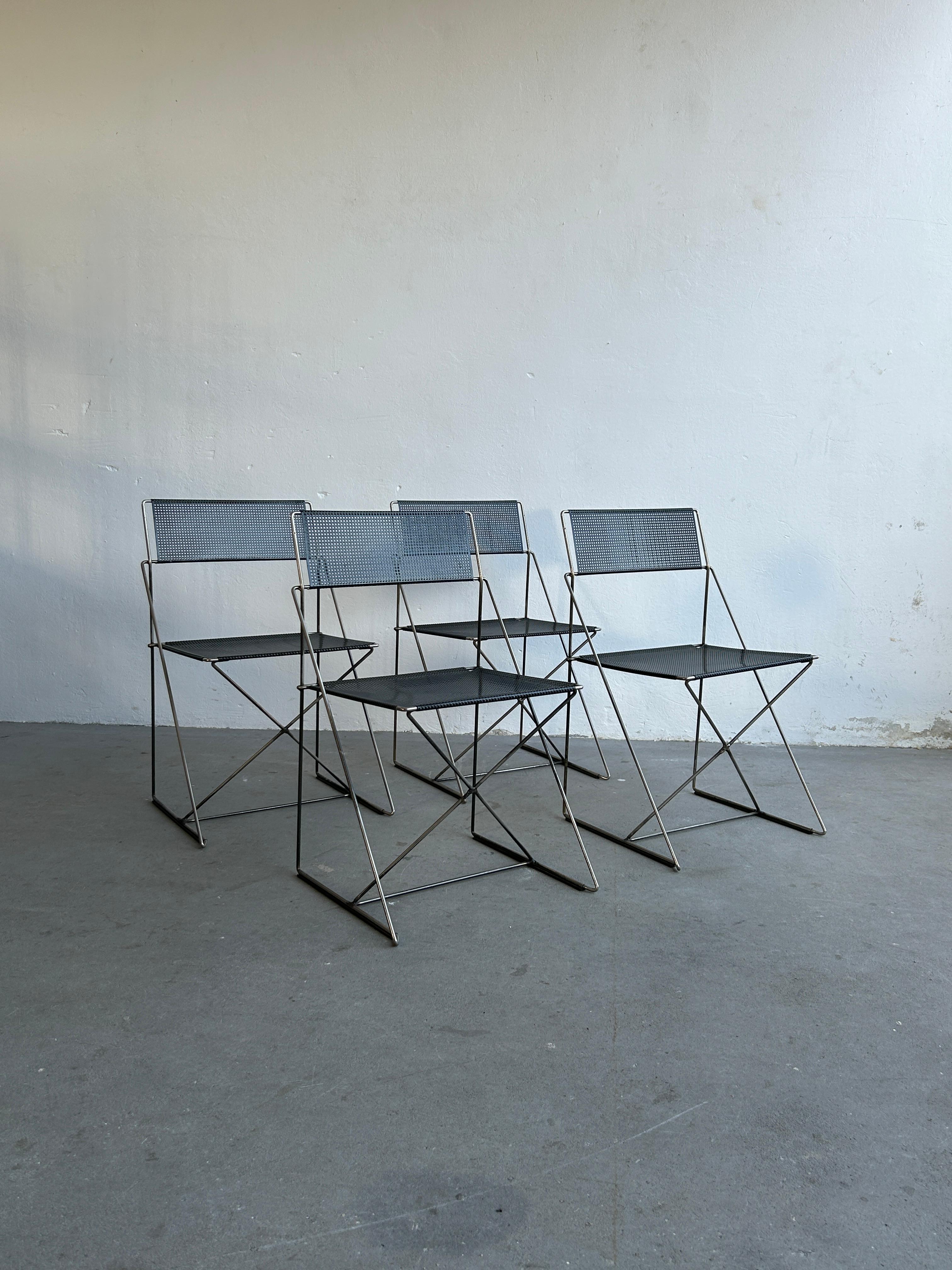 Set of four minimalist postmoderns X-Line chairs designed by Niels Jorgen Haugesen for Magis.
Made of chrome plated steel rods and black enamelled perforated steel backs and seats.
Stackable.

In very good vintage condition with expected signs