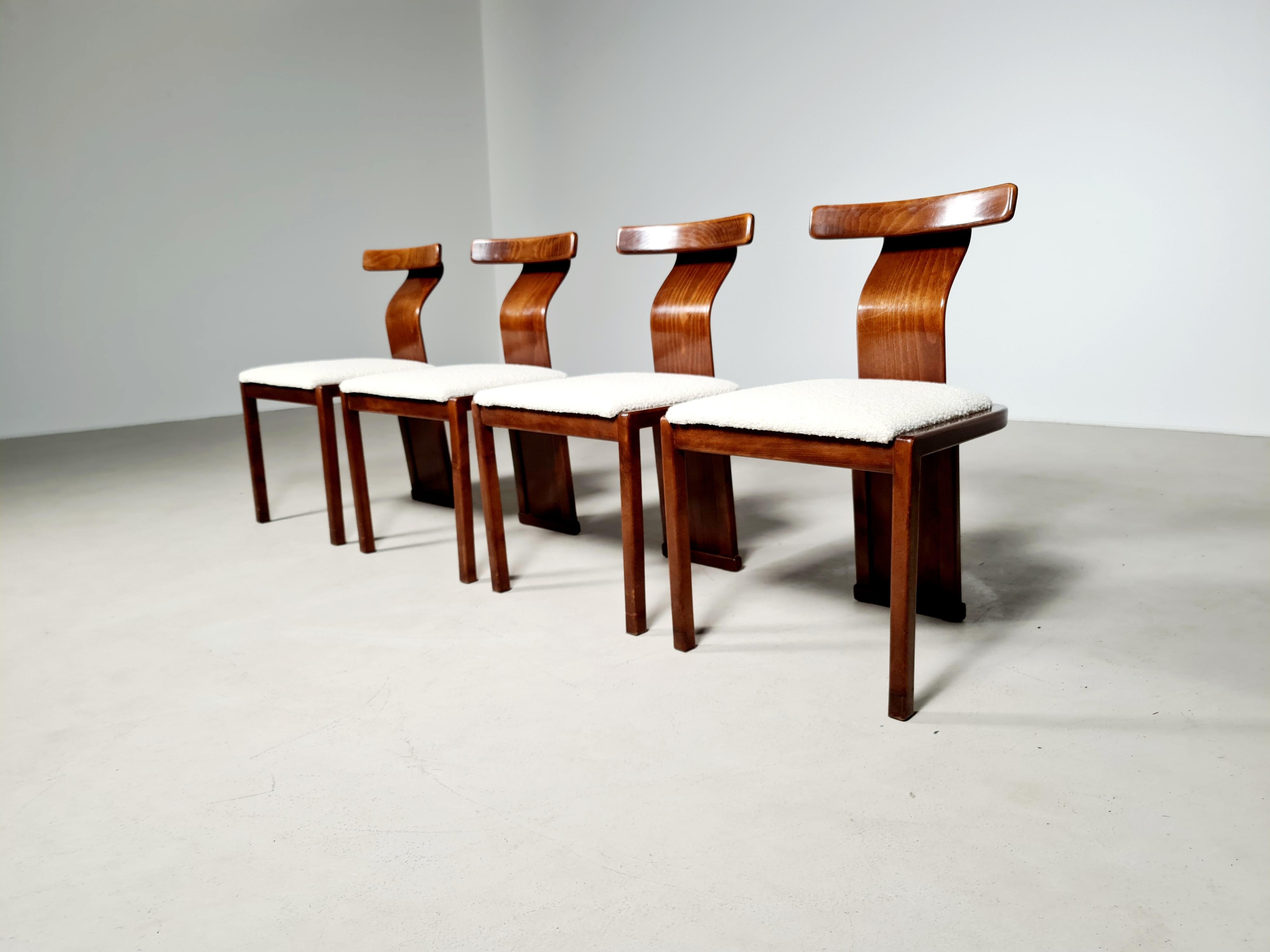 Set of four vintage sculptural chairs with wonderful backrests from Italy, 1960s. The color of the Italian laquered walnut frame is deep and warm which accompanies the reupholstered boucle seats very well.