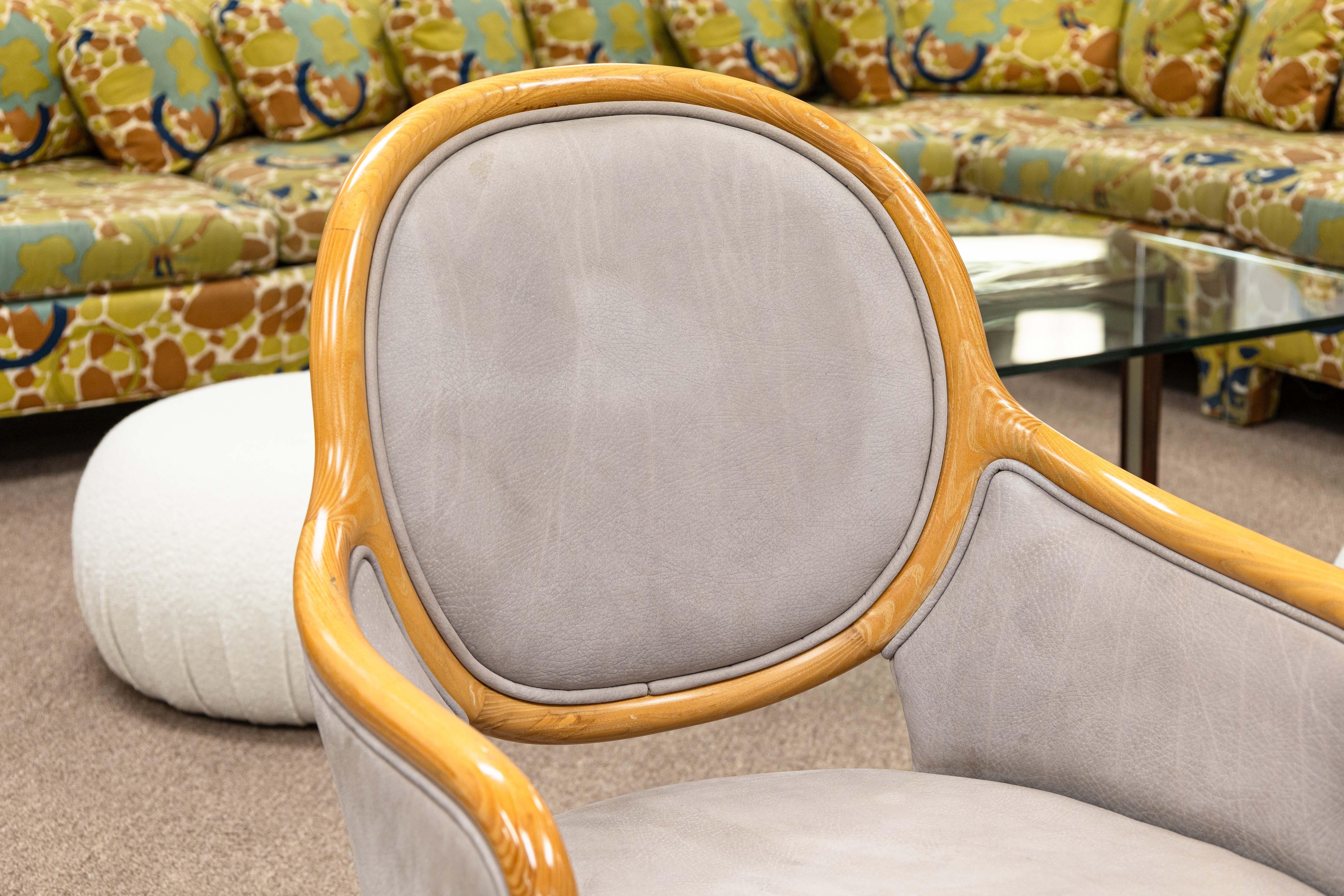 A set of 4 Ward Bennett for Brickel Associates dining chairs. This beautiful set of luxe dining chairs feature an ash wood frame with an oiled finish, and a mauvey/lavendery leather seat and body. Each of these pieces features a unique design. The