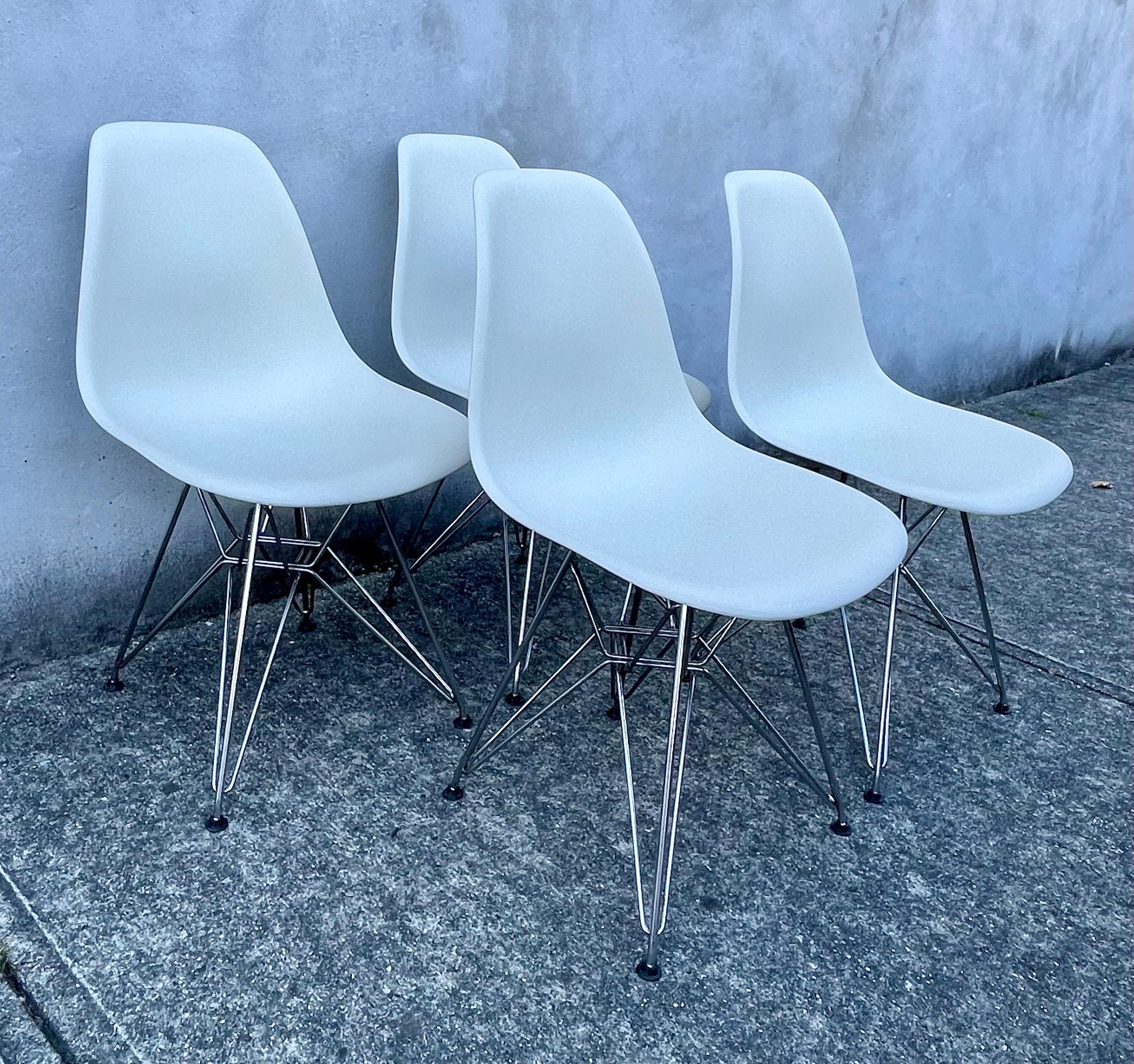 Set of 4 Eames white molded plastic dining chairs with chromed steel Eiffel Tower base, 2010 production.