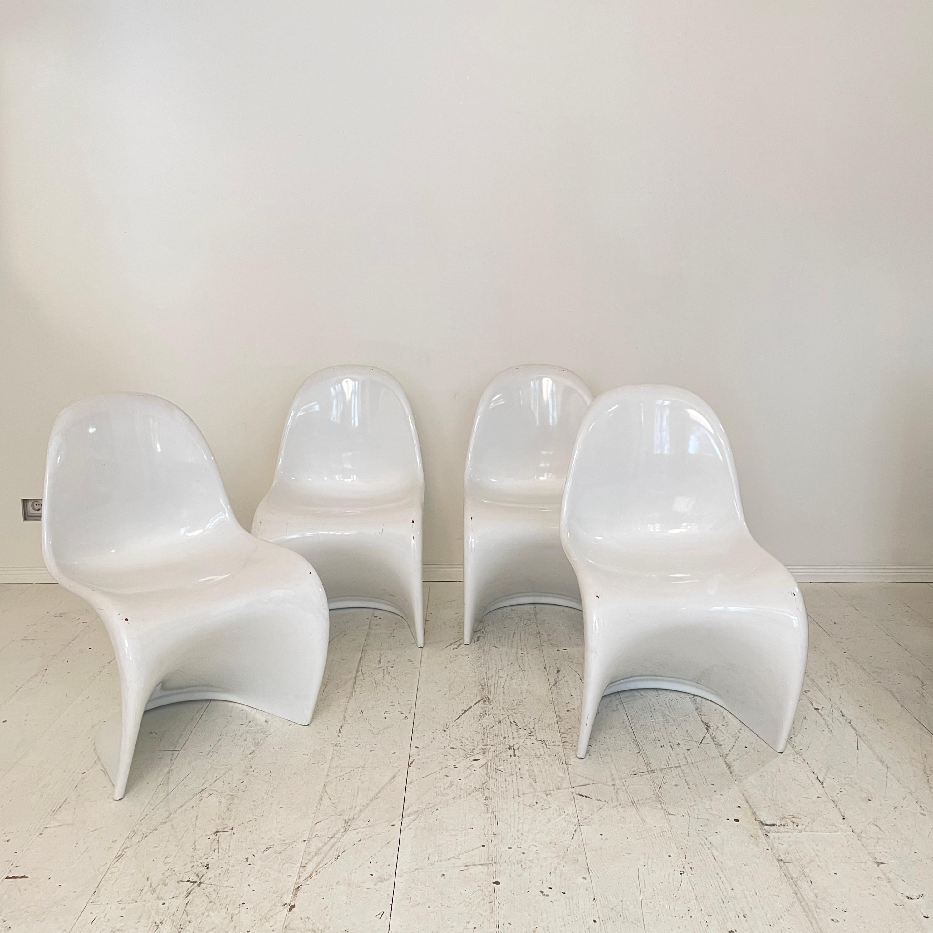 Those original and rare 1st edition of the dining chair, designed by Verner Panton in 1950s where produced for the first time in the middle of 1960 in a mix of polyester with fibreglass. 
This Set comes in white and was made in the mid 1960s by