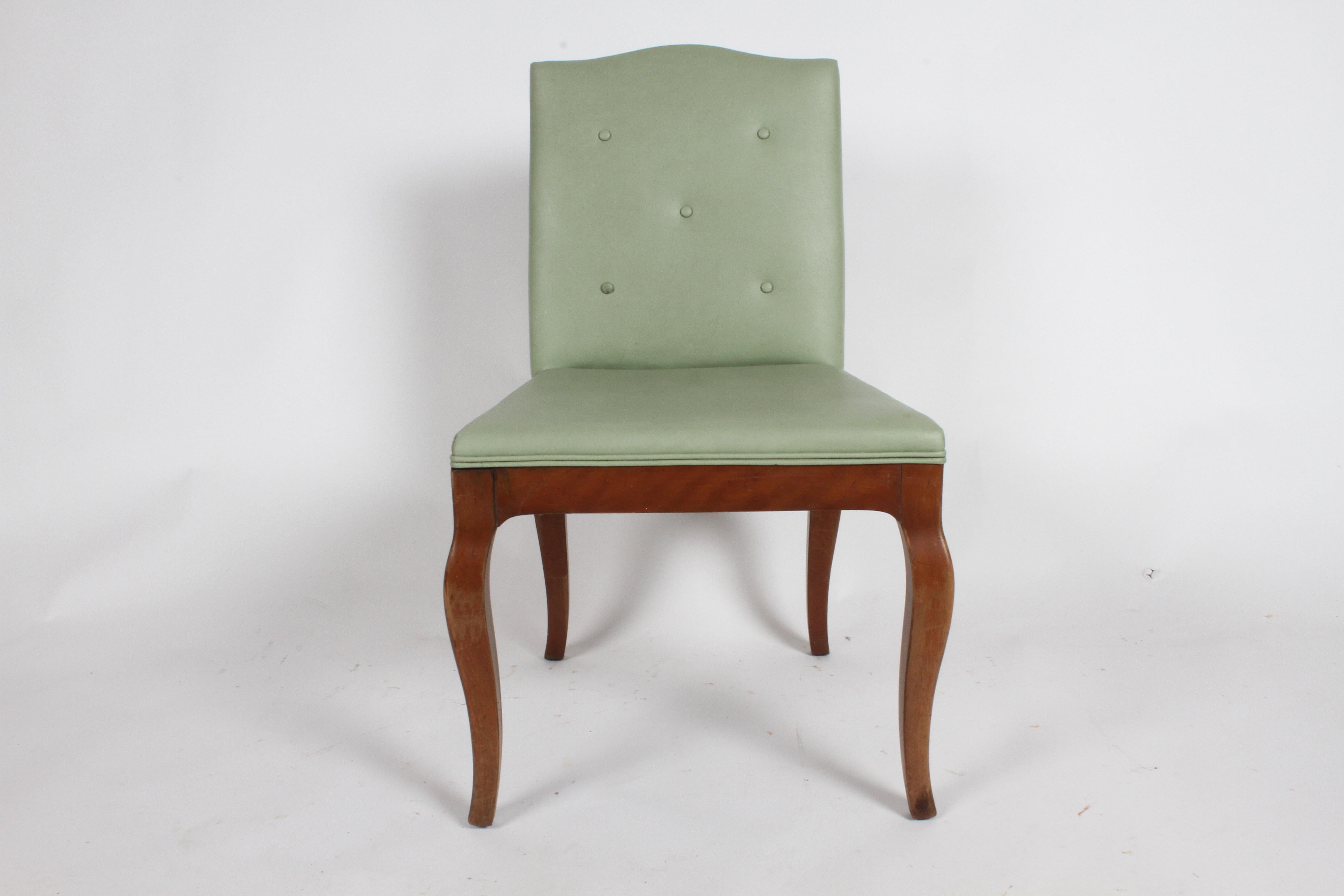 Set of four William Billy Haines style dining or game table chairs with sculpted modern cabriole legs and tufted faux green leather backs. The backside of the chair has nice inset mahogany frame , revealing tufted buttons. These chairs are in need