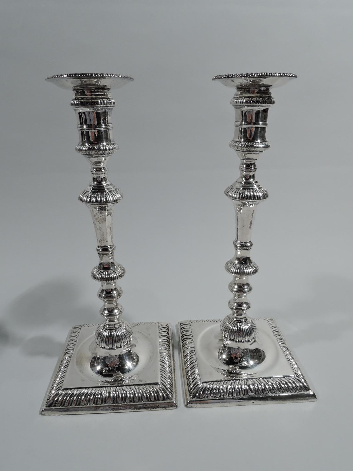 Set of 4 George III sterling silver candlesticks. Made by William Cafe in London in 1763. Each: Girdled spool socket with detachable bobeche. Faceted and knopped tapering shaft on raised foot flowing into concave circle on square base. Gadrooning.