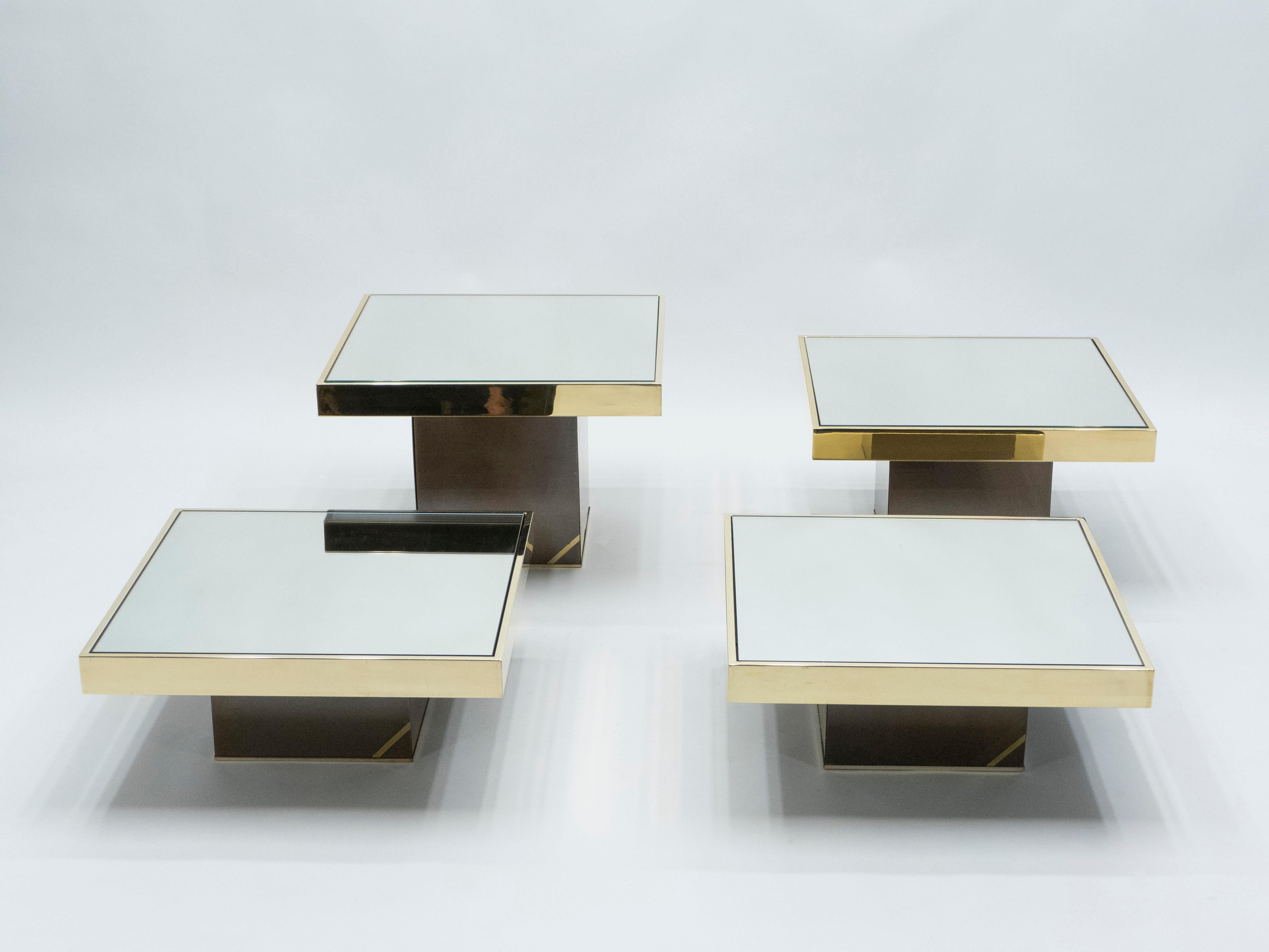 Celebrated luxury furniture designer Willy Rizzo designed this set of 4 coffee tables for Cidue Italy in the 1970s. Light reflecting qualities abound as the mirrored surfaces are wrapped in shiny brass. Chunky blocks of gunmetal with brass accent