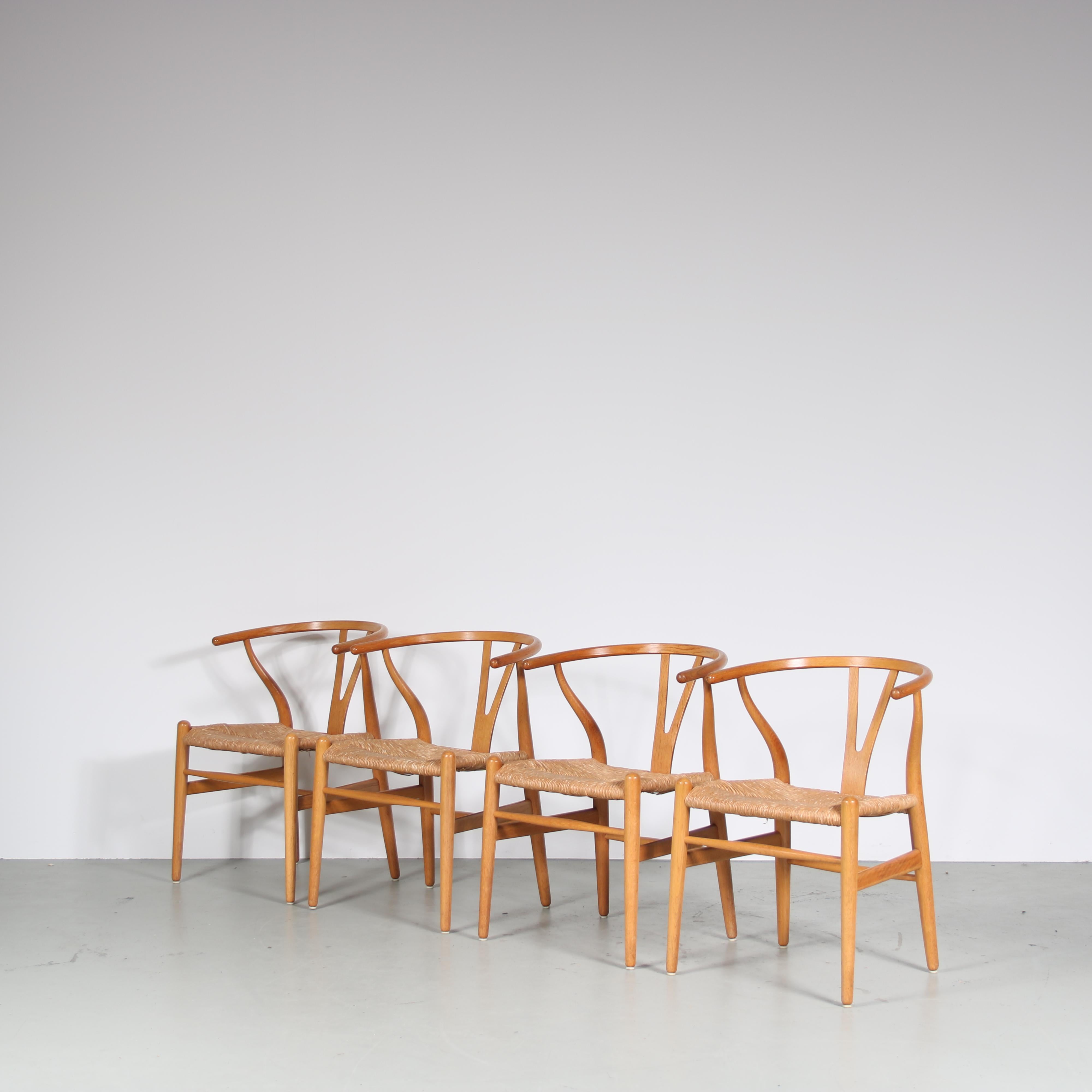 In the 1970s, renowned Danish designer Hans J. Wegner created this exquisite set of four oak wishbone dining chairs with rush seats, manufactured by Carl Hansen in Denmark. These chairs are a true testament to Wegner’s mastery of craftsmanship and