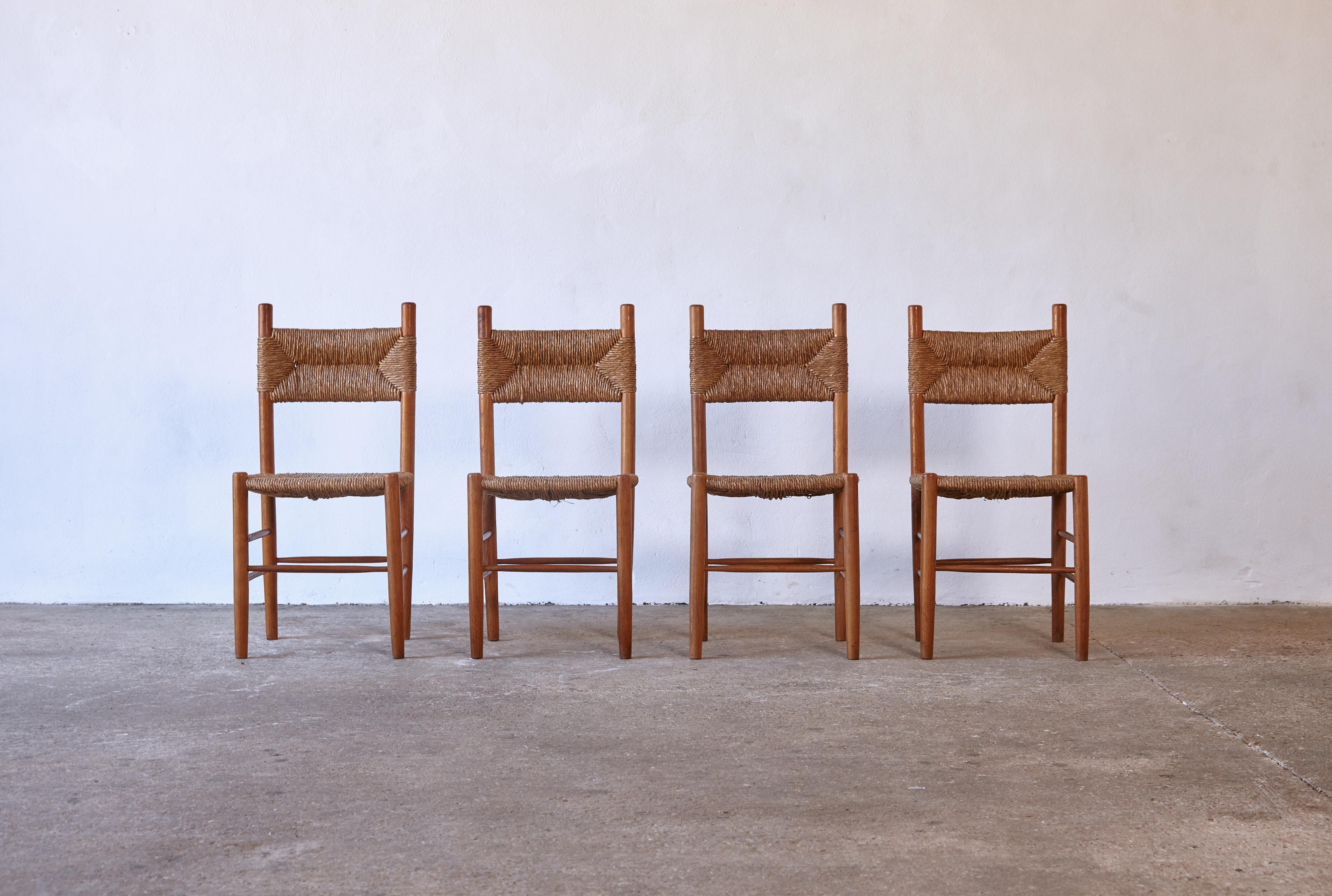 A set of four wood and rush dining chairs, France, 1960s. Very similar to Robert Sentou / Charlotte Perriand Dordogne chairs but with a slightly higher back. Ready to use, the wooden frames in original condition with minor signs of use and wear