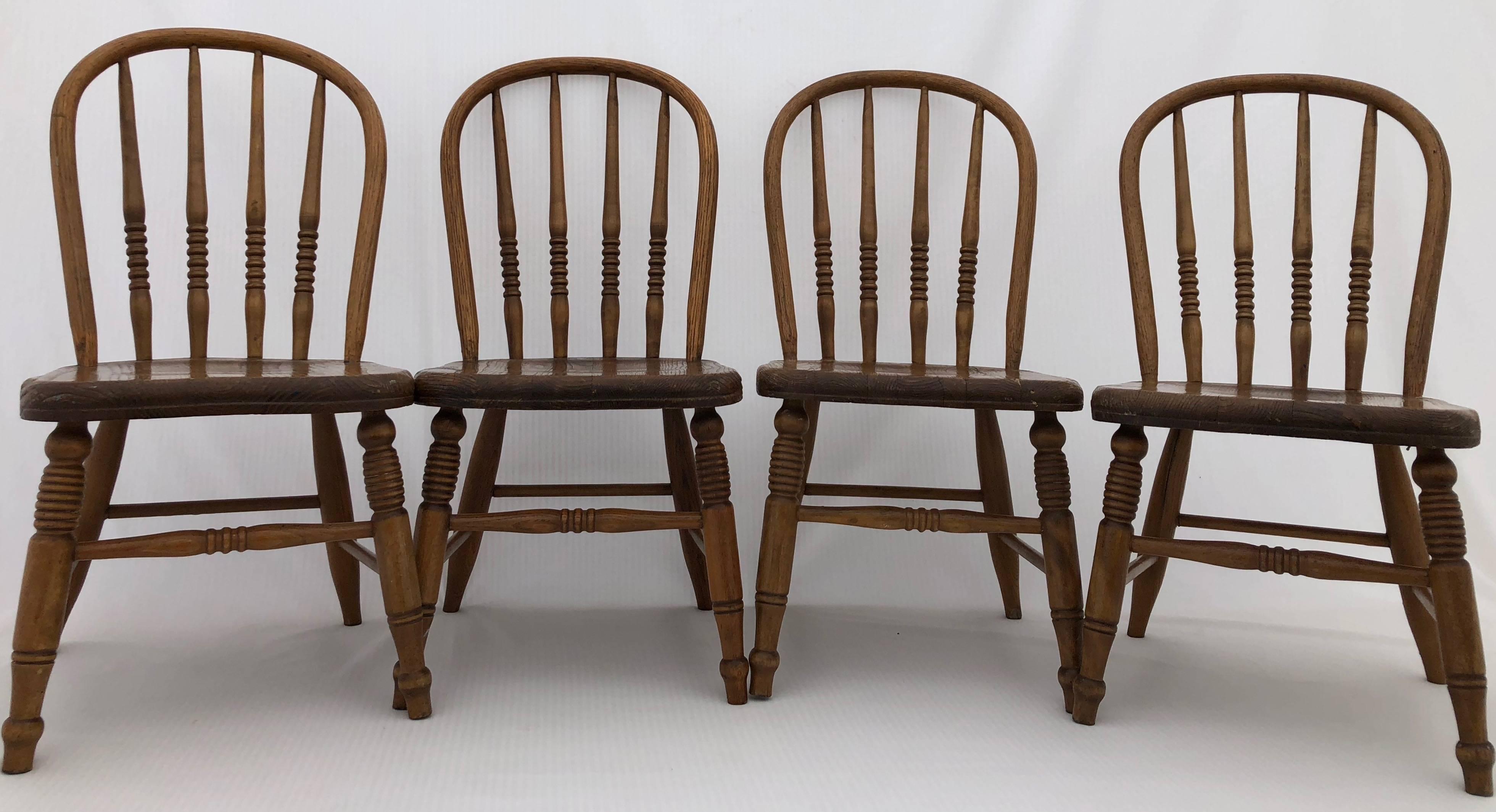 This set of four wooden children's chairs are lovely. They are solid and have spindle, rounded backrests. They are beautiful seats in a great patina and could be used for children to use or as a decorative element.