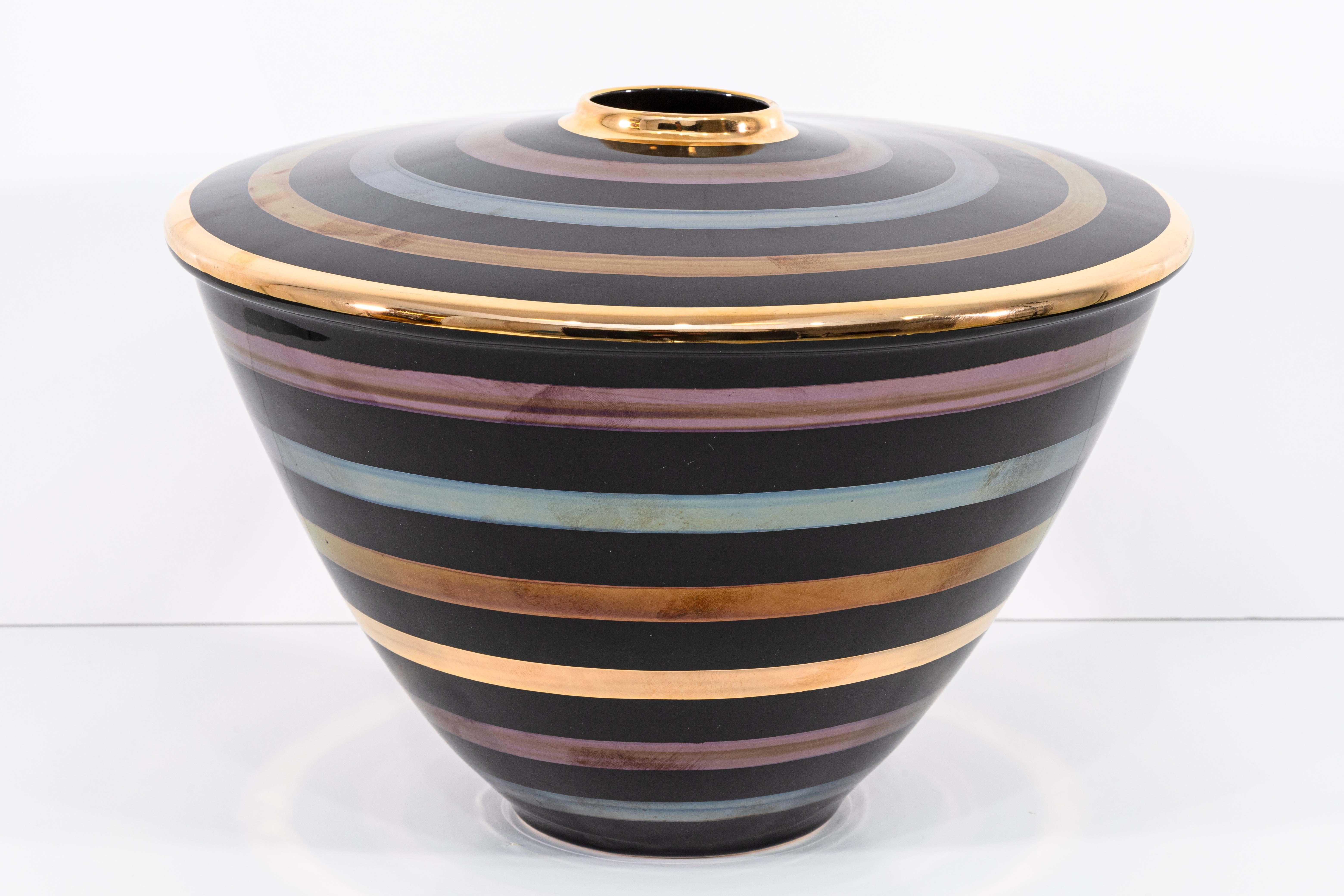 Un set di 4 vasi in ceramica Yapacunchi Ceramica. Questo divertente set di vasi presenta una varietà di forme, dimensioni e usi, ma tutti belli e decorativi. Ogni pezzo ha una base nera con strisce d'oro, viola, blu e bronzo. La finitura è lucida e