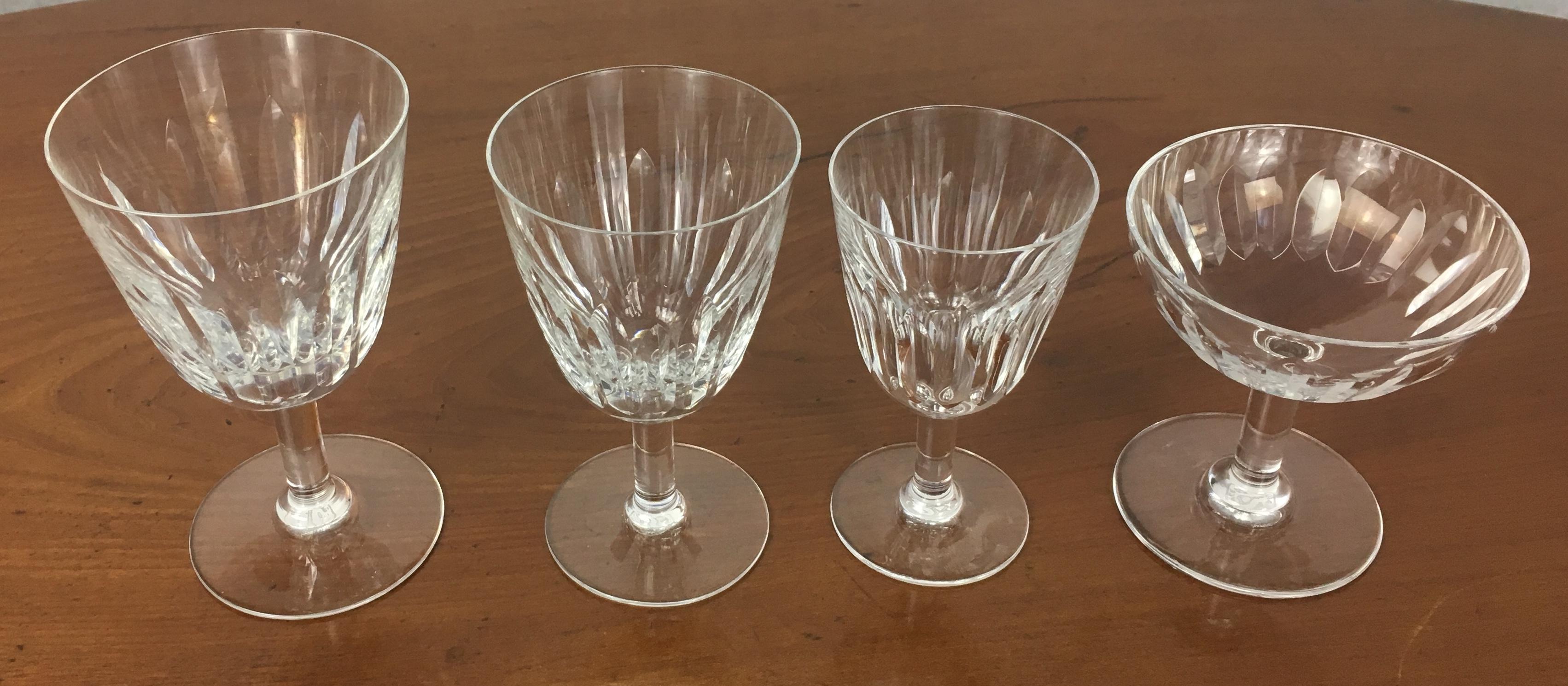 Set of forty six Baccarat crystal white and red, water glasses and coupes de champagne, water in the 'Verone' pattern. The glasses are in a vertical cut bowl form with a six-sided stem. This pattern was manufactured between 1954-1961.

The glasses