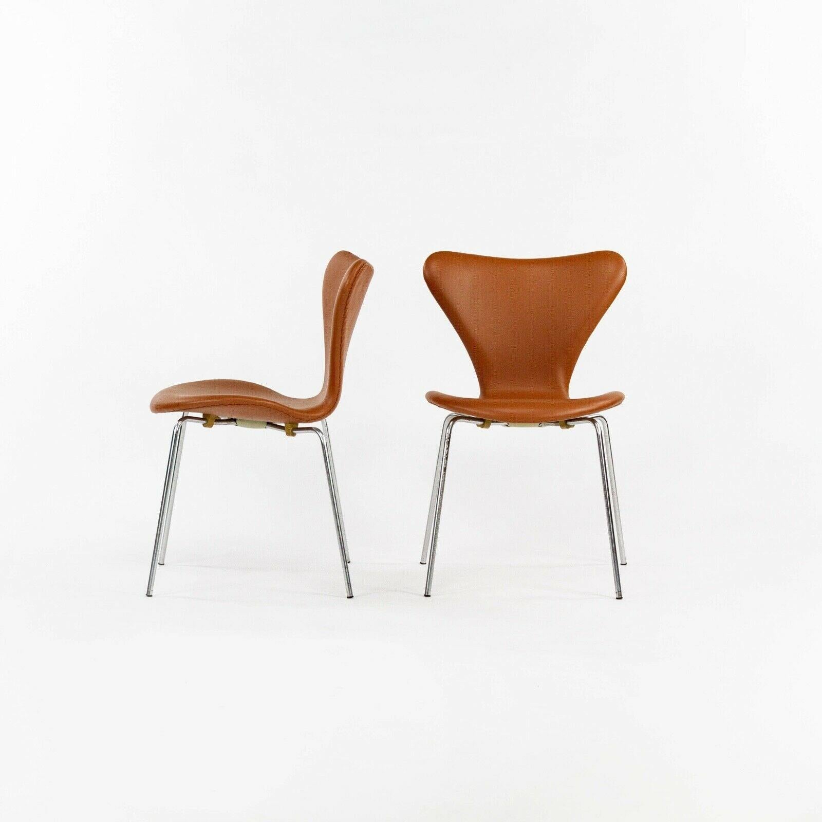 Listed for sale is a set of four (the price listed is for four, however, up to eight side chairs are available and additional armchairs also) Arne Jacobsen Series 7 armchairs in cognac leather. These chairs were just masterfully reupholstered by one