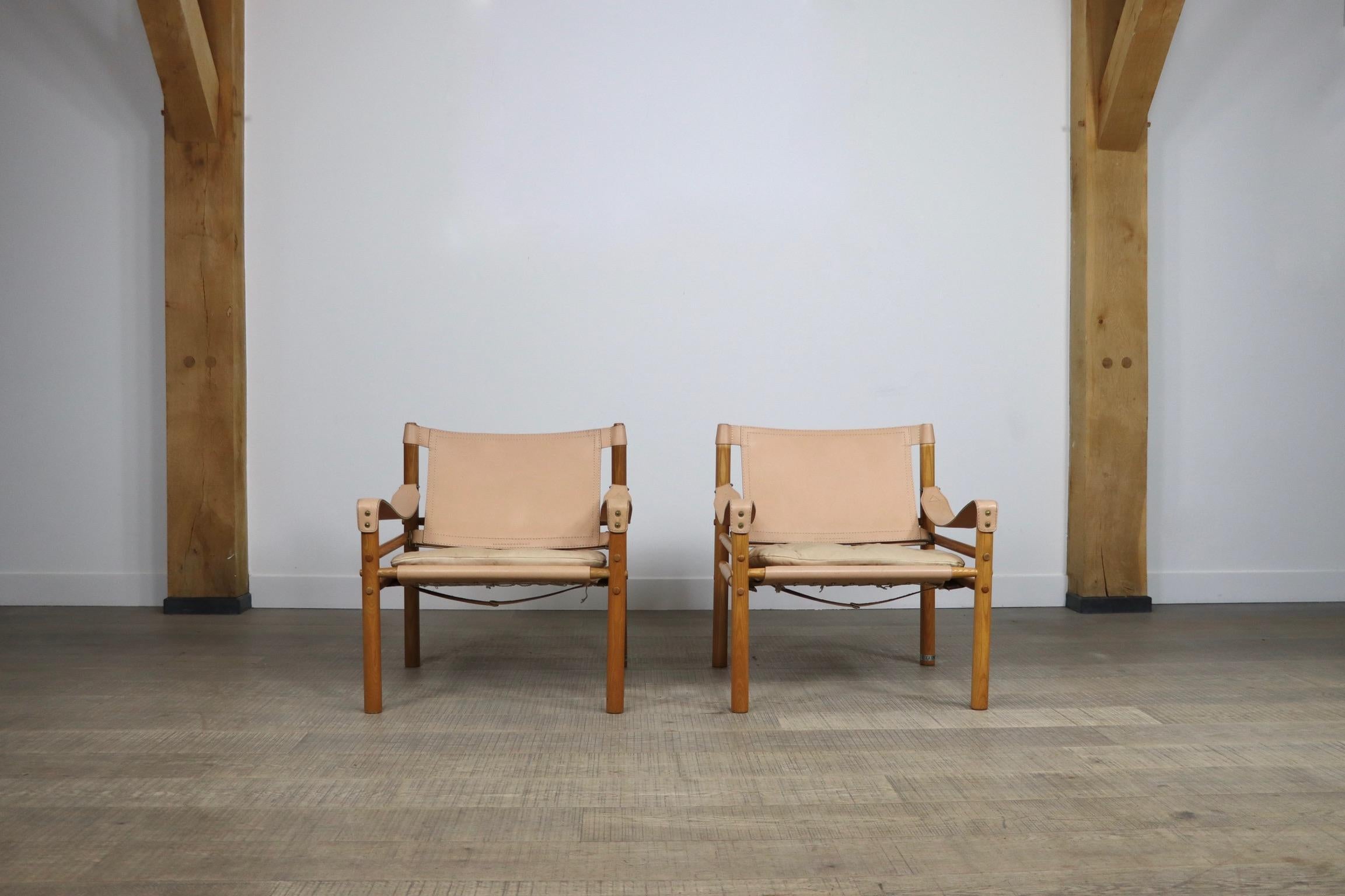 Set of 2 Sirocco easy chairs model Sirocco in light peach leather designed by Arne Norell, Produced by Arne Norell AB in Aneby, Sweden. These chairs are made of an ashwoord frame and original light peach leather seating and armrests with a soft