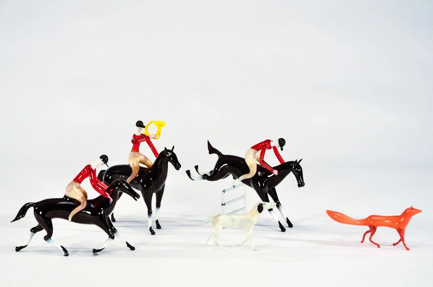 This is an extremely rare set of hand blown Bimini figures depicting a complete collection of a hunt scene. The set consists of 3 horseback riders, one of which is jumping a fence, a fox and terrier all in amazing large scale. A wonderful choice for