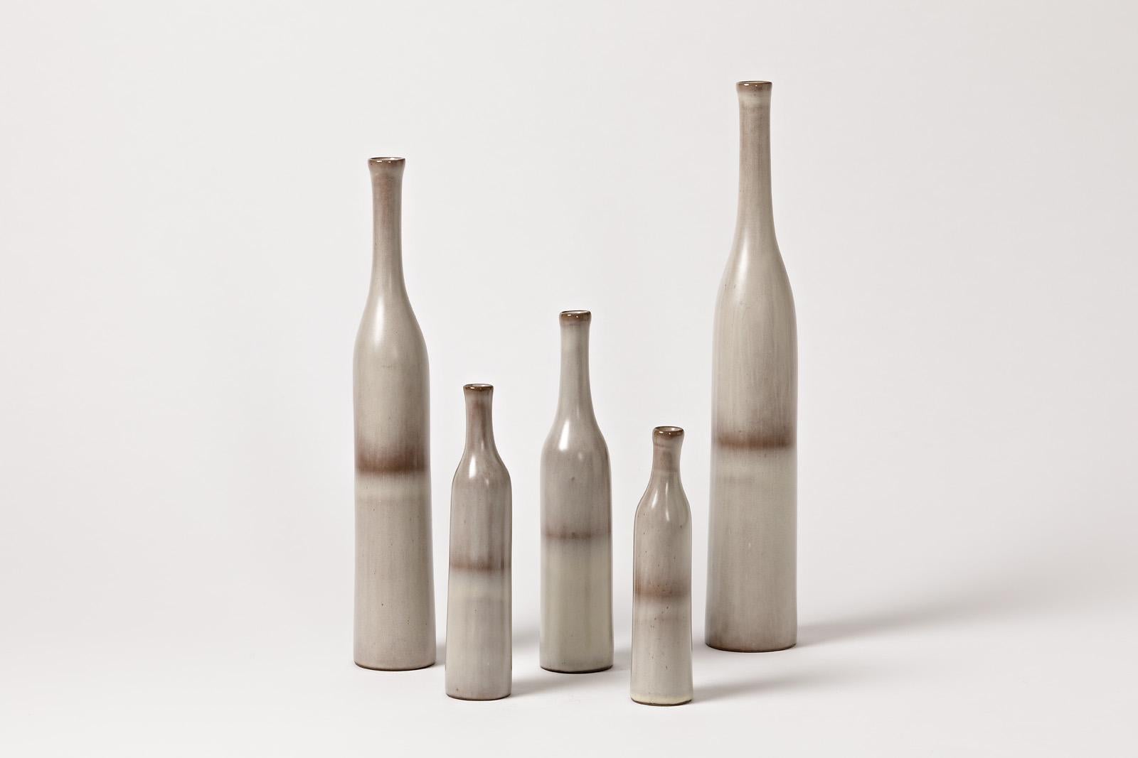 Jacques and Dani Ruelland

Rare original set composed of 5 ceramic bottles.

Excellent original conditions. Each one is signed under the base RUELLAND.

White and grey ceramic glaize colors.

Dimensions: 35 x 6cm / 31 x 5cm / 21.5 x 4.5cm /